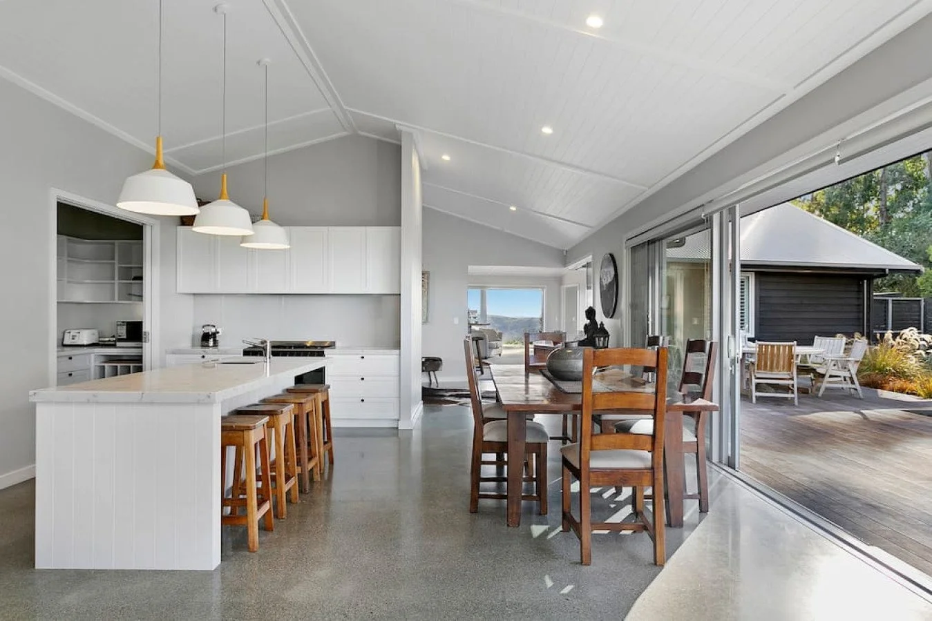 Open-concept kitchen and dining area with sliding glass doors leading to an outdoor patio with outdoor seating.