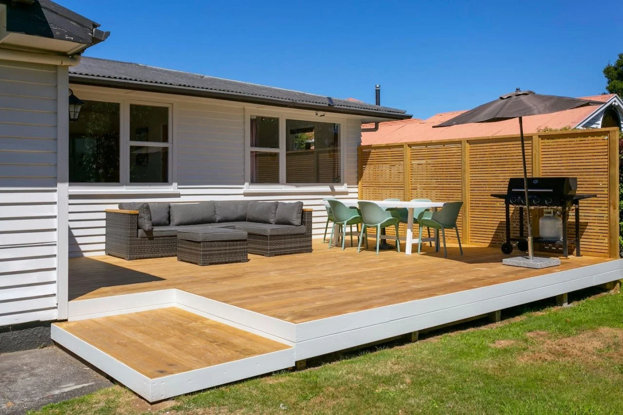 Backyard patio with outdoor furniture and a barbecue grill under a clear blue sky