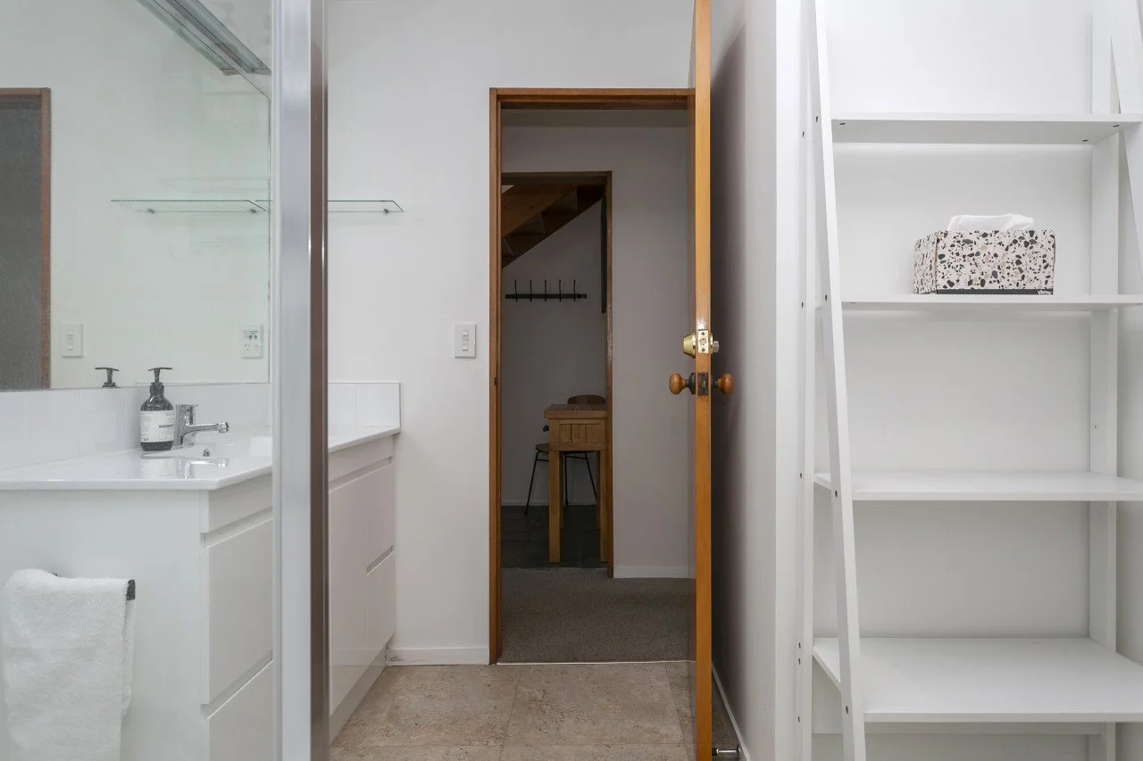 Bathroom and closet doorway with a ladder shelf and a box of tissues