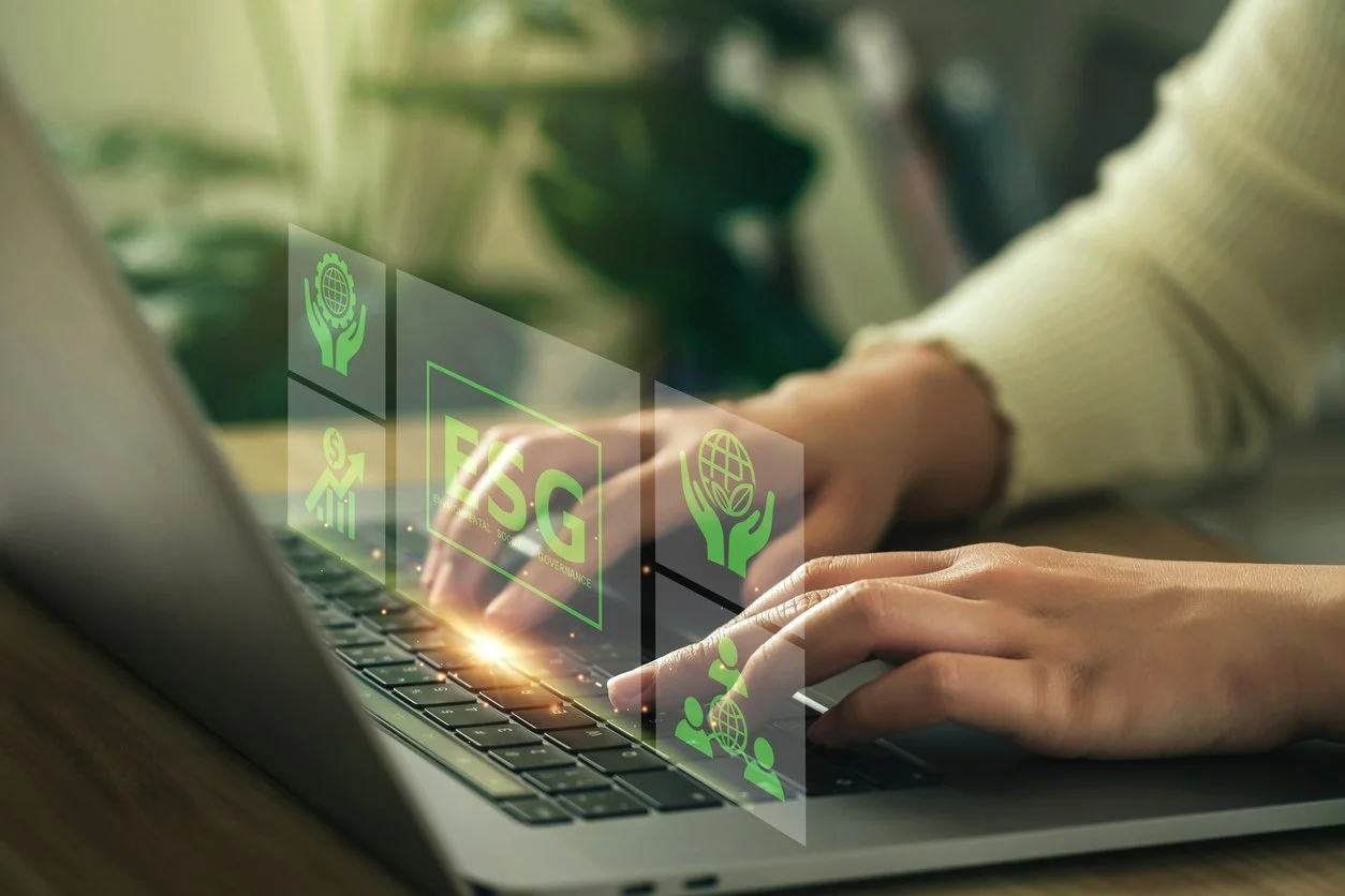 Person typing on a laptop with floating icons related to environmental sustainability, global governance, and ESG initiatives.