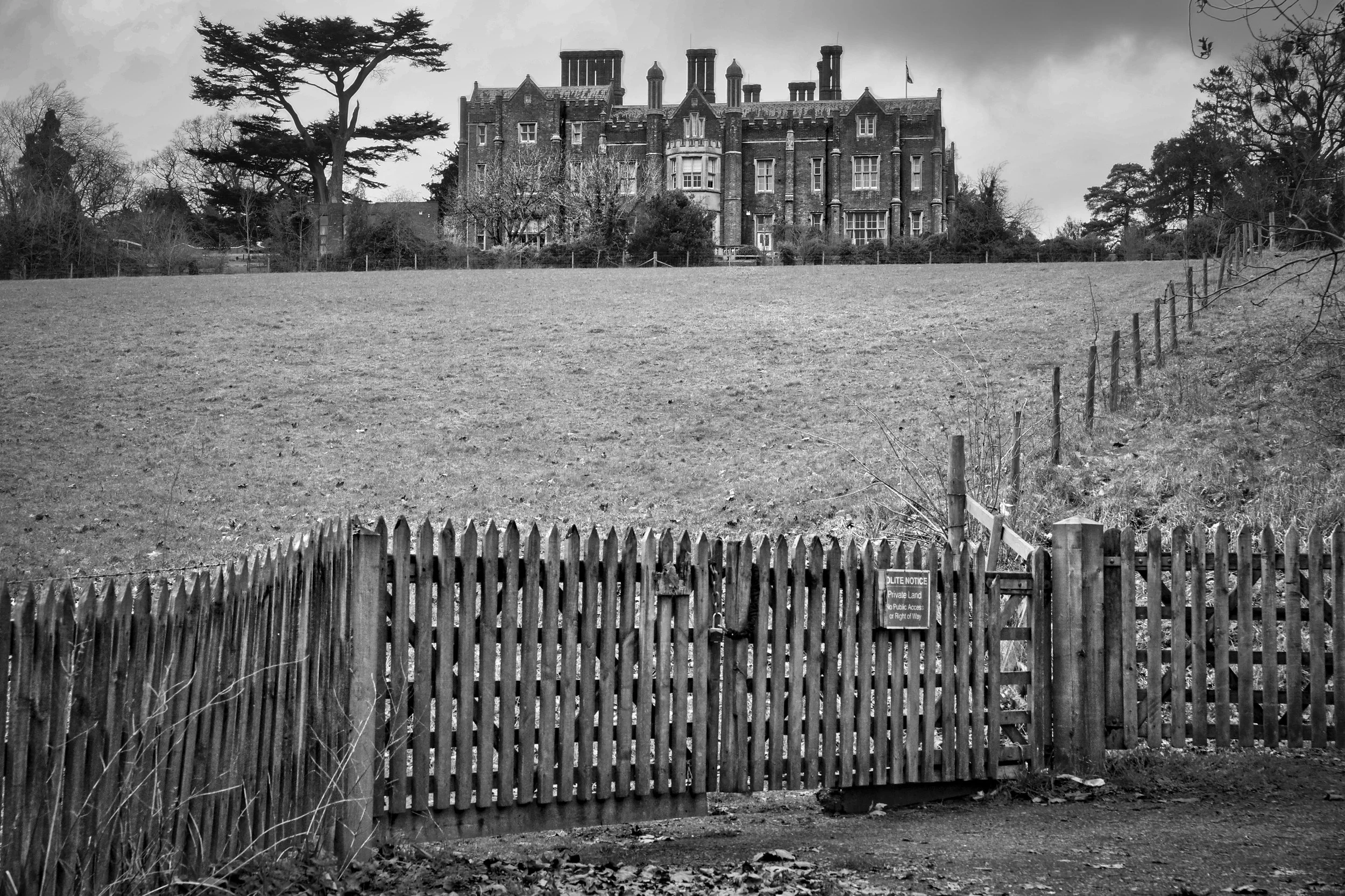 Latimer House viewed from the valley below, private land gate and fence in the foreground, Chess Valley, Buckinghamshire, black and white