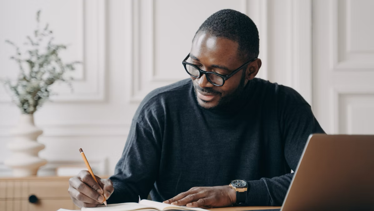Man working at a desk, focused and engaged, representing professional communication and vocal confidence by Peacock Voices