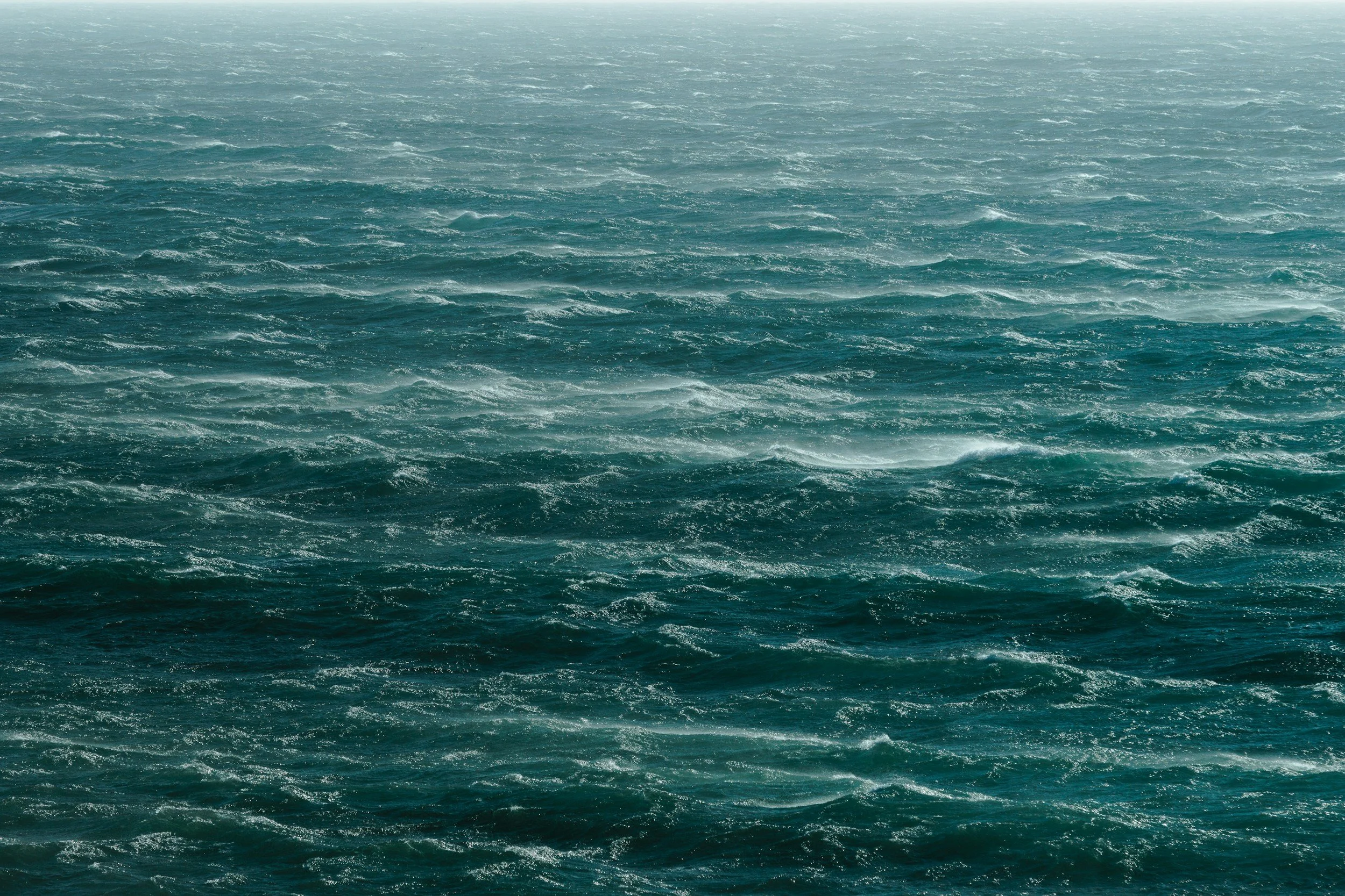 Open ocean with turbulent waves under a cloudy sky