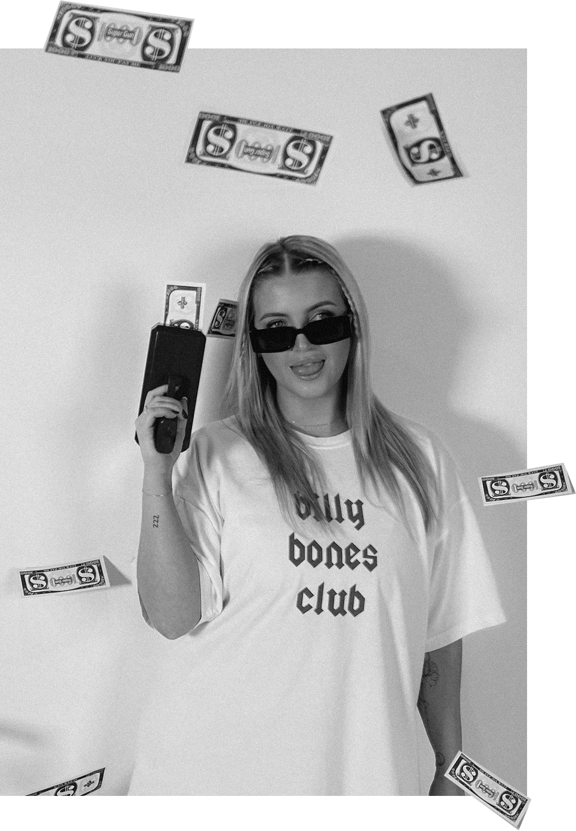 Jess Morgan wearing sunglasses and a t-shirt that says "bully bones club," stands in front of a plain wall with digital dollar bills and a gun edited into the image, with some appearing to fall around her.