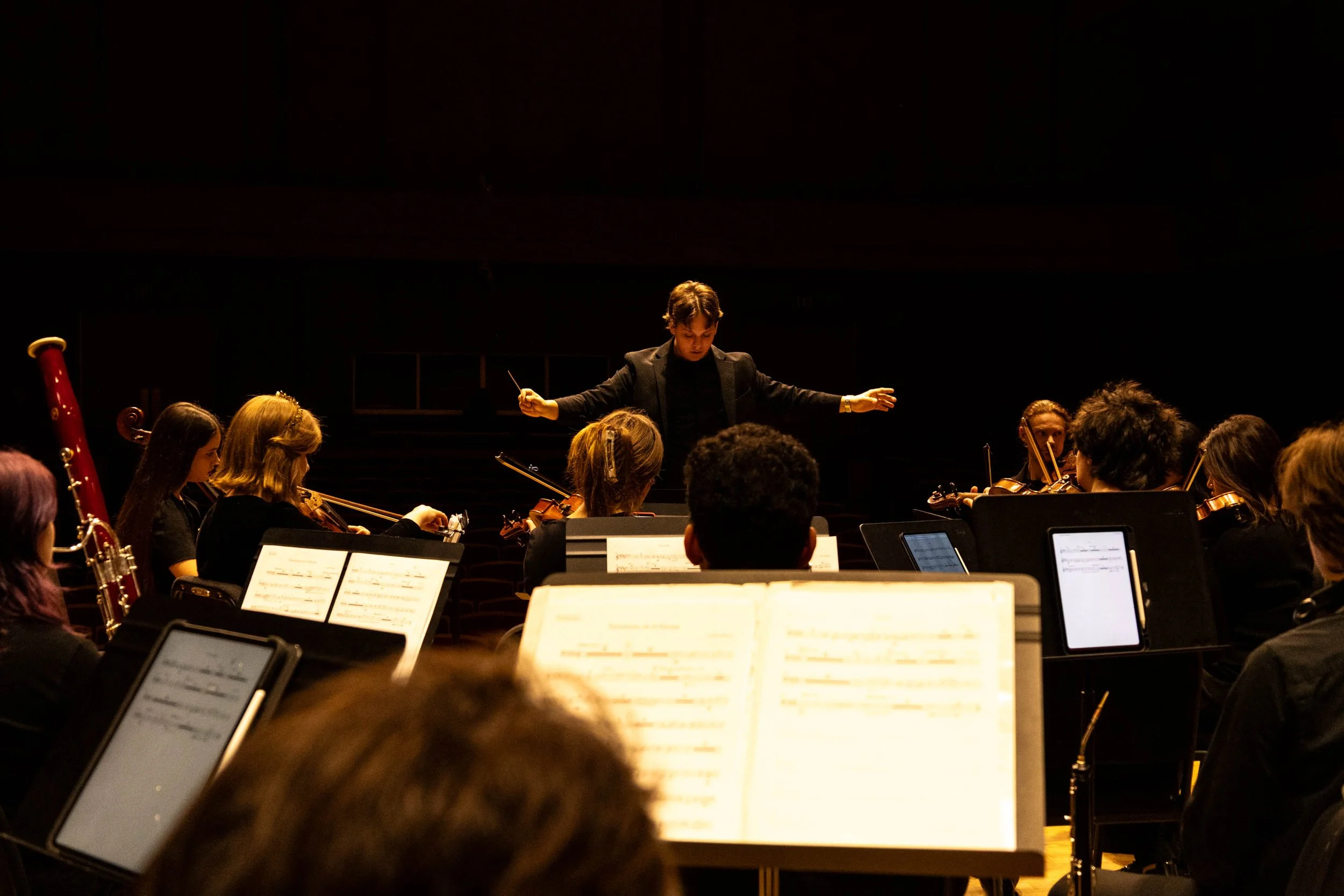 In the Paul Voertman Music Hall, Music Composition junior Collin Huffman conducts the ensemble into a crescendo during dress rehearsal on Saturday, February 21. Huffman co-wrote this concerto, titled Variations on A Dream, with fellow junior music co