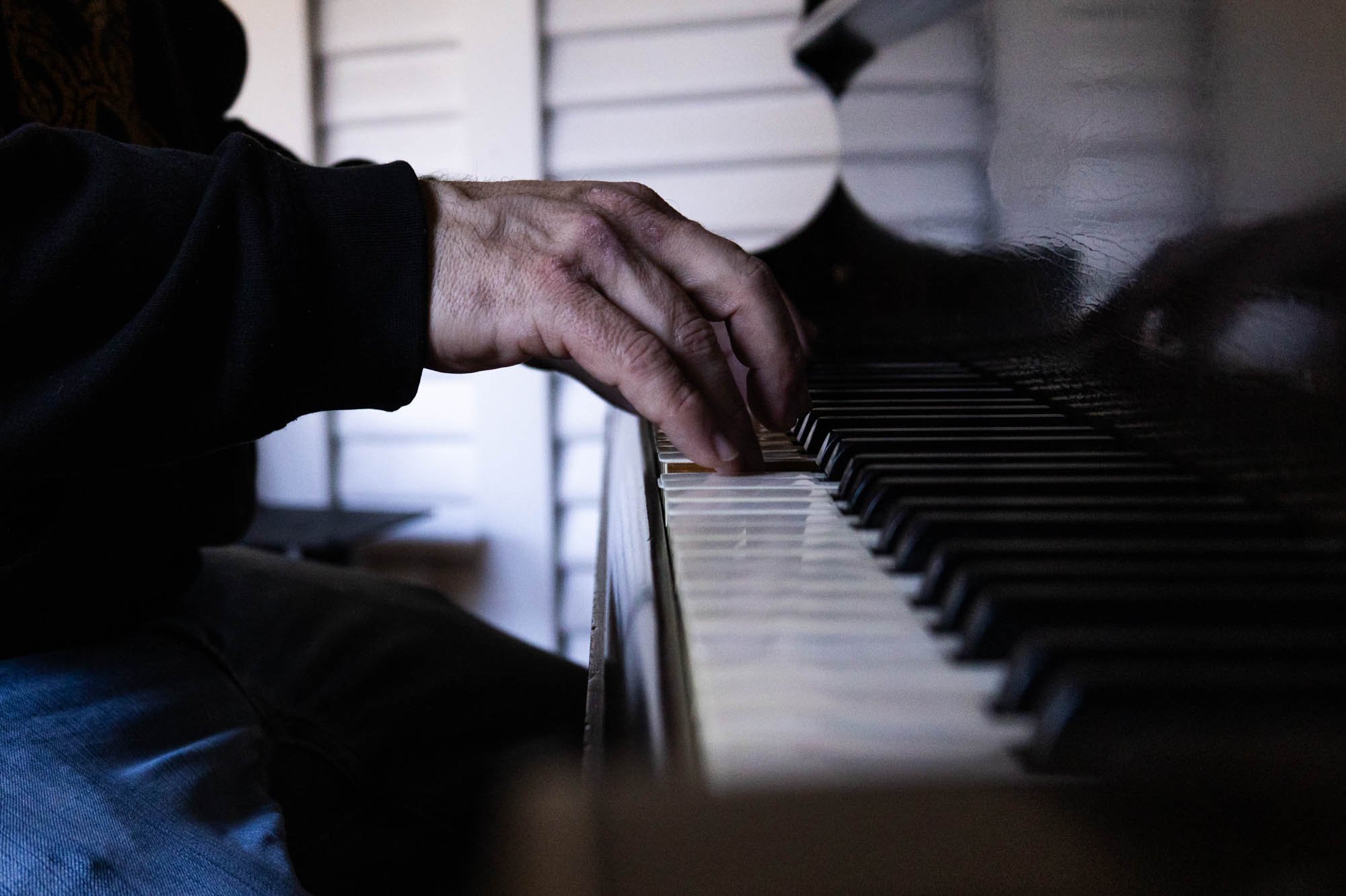 David Pierce plays a tune on his baby grand piano.