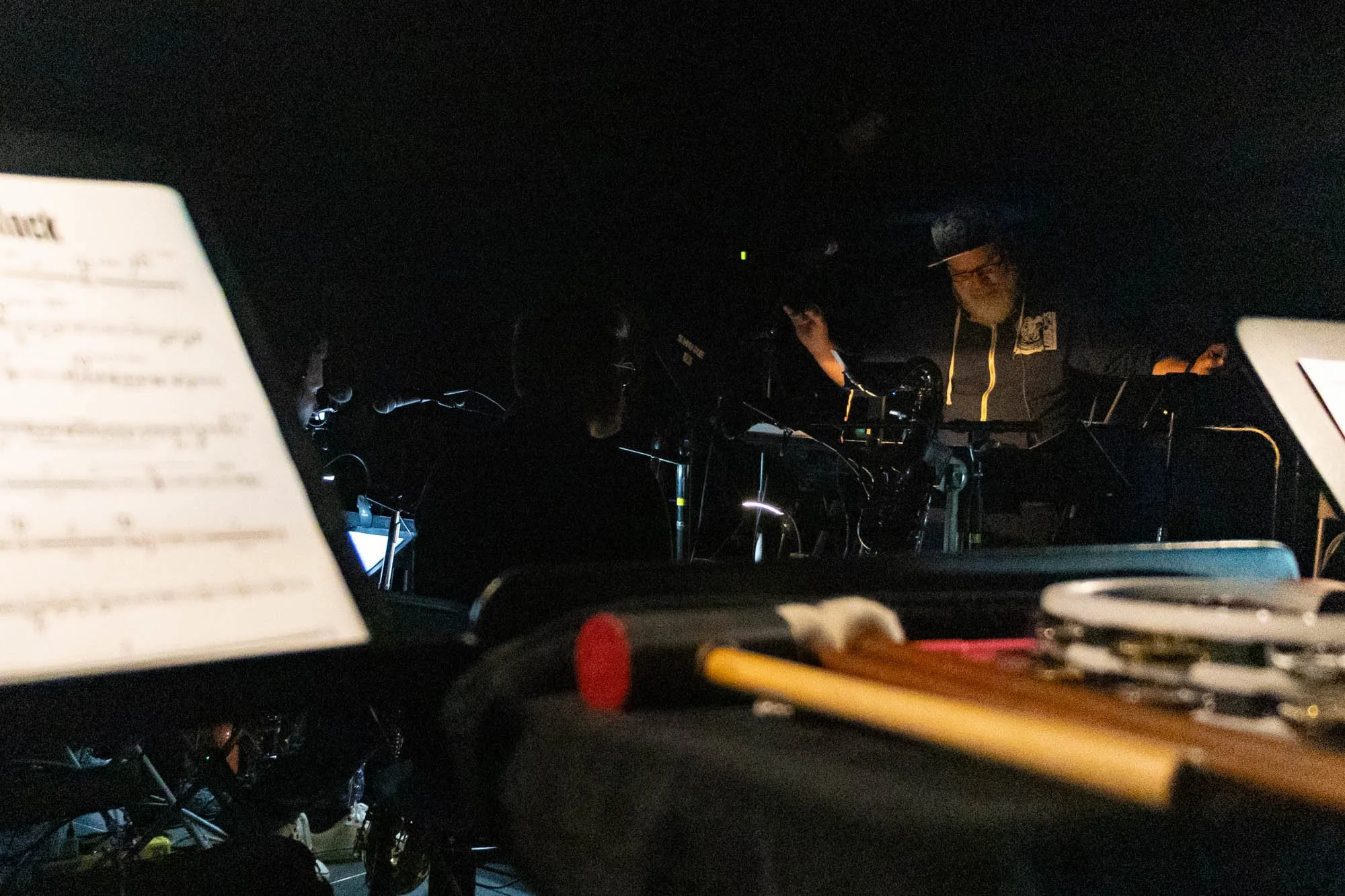 While conducting the orchestra pit for the song "The Old Clock," Pierce gestures at the chorus members standing beside the stage.