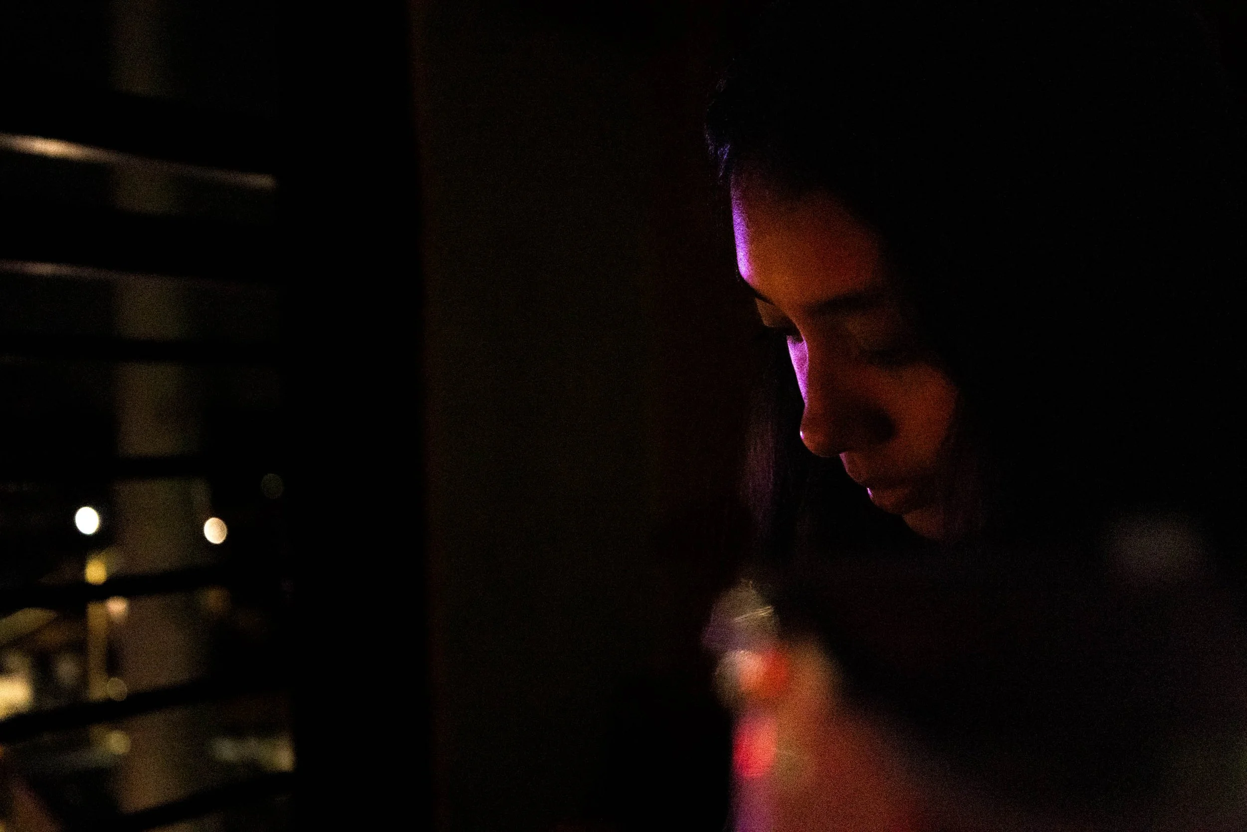 Sitting on her 4th floor balcony, UNT Finance senior Briza Pozos answers a text from a friend. The balcony overlooked Bernard Street, where a cop car's lights illuminated the whole block.