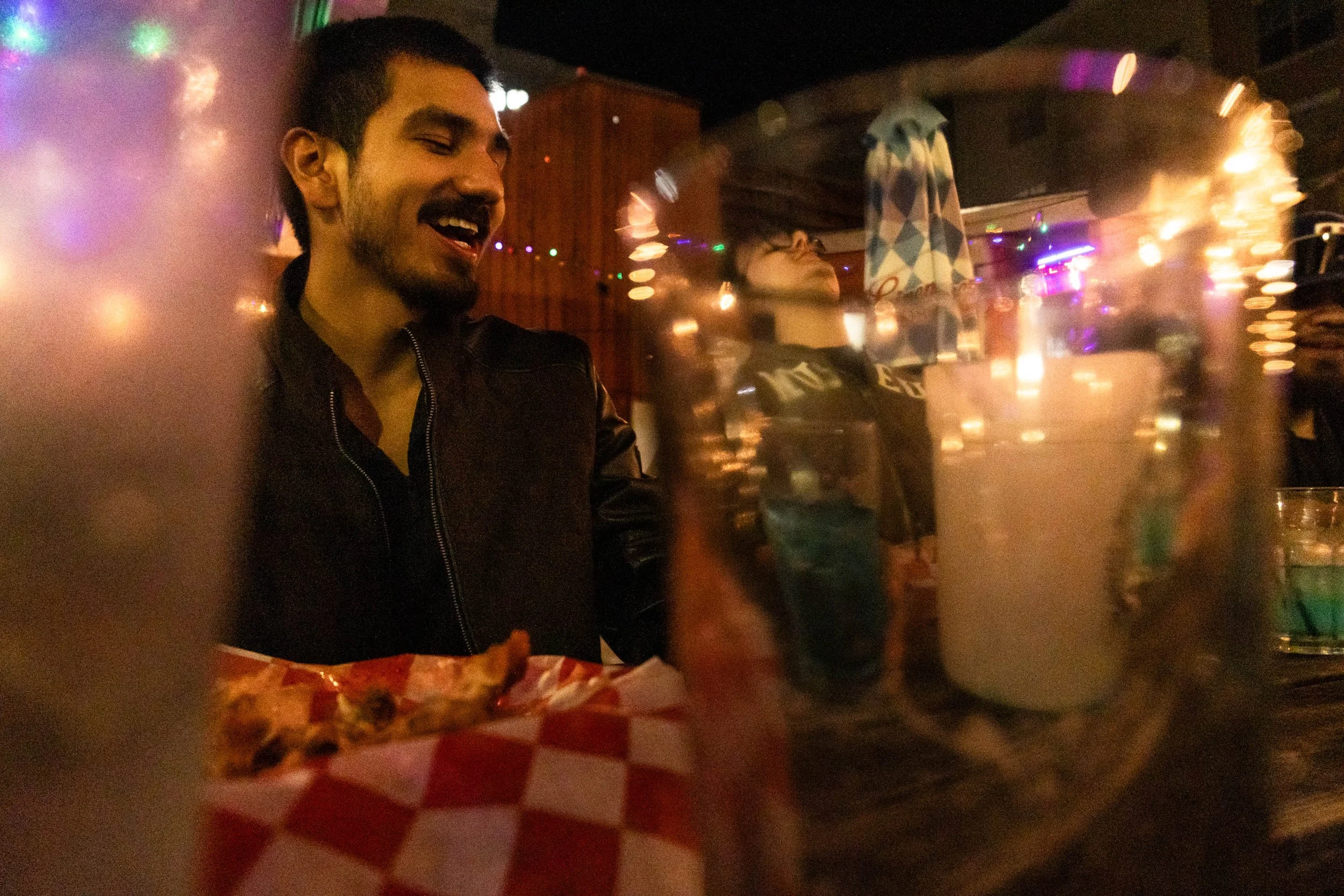 College Dive Bar - University of North Texas graduate student Max Munguia shares a joke with his friends at Cool Beans on Fry Street. The Cool Beans patio, where Munguia sat, is a popular hangout spot for UNT students.