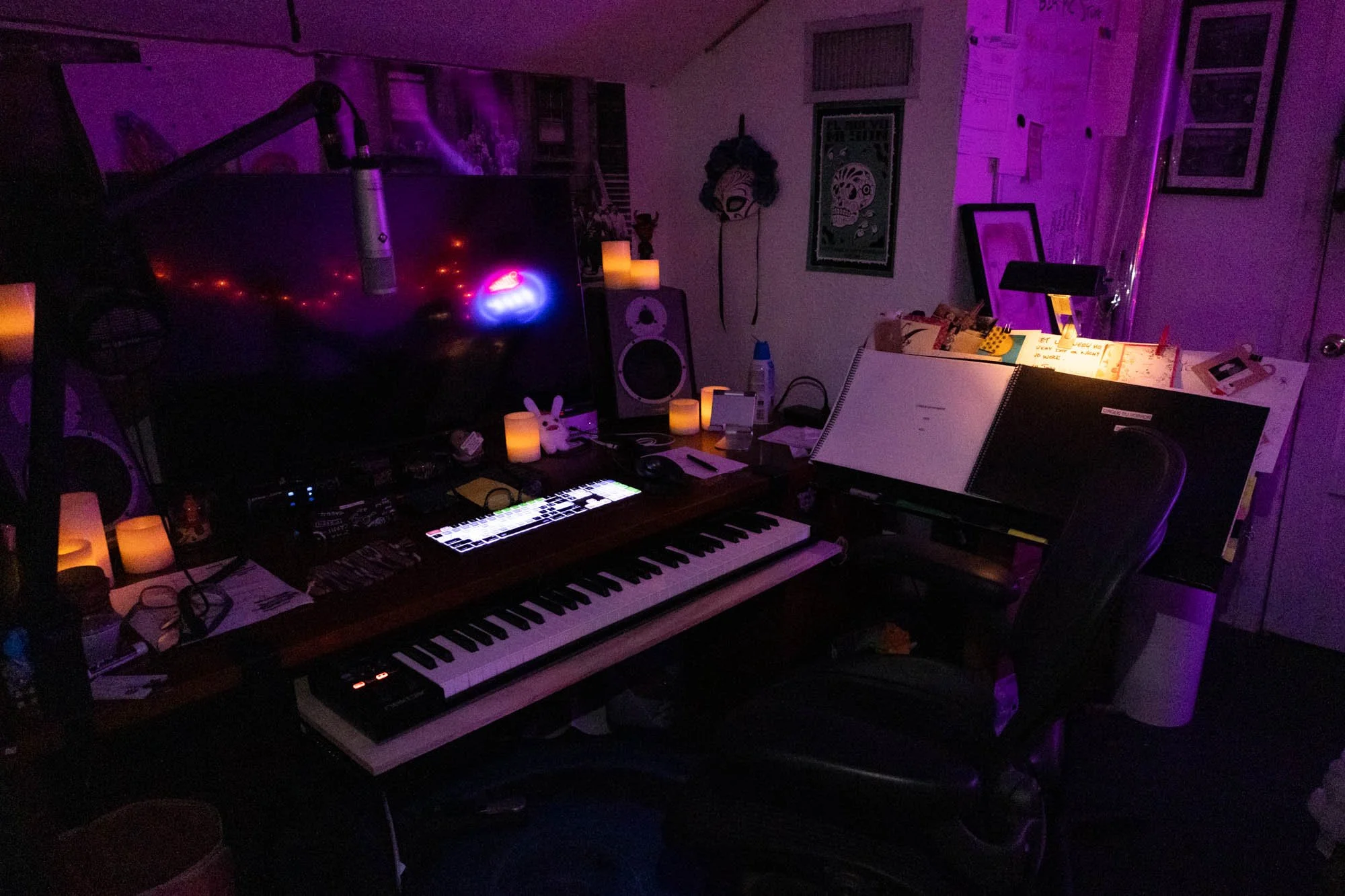 In the attic space of Pierce's house sits his studio, full of years of Cirque du Horror sheet music and planning. His desk features a keyboard, a microphone, and numerous sheets of notes for Cirque du Horror 2026.