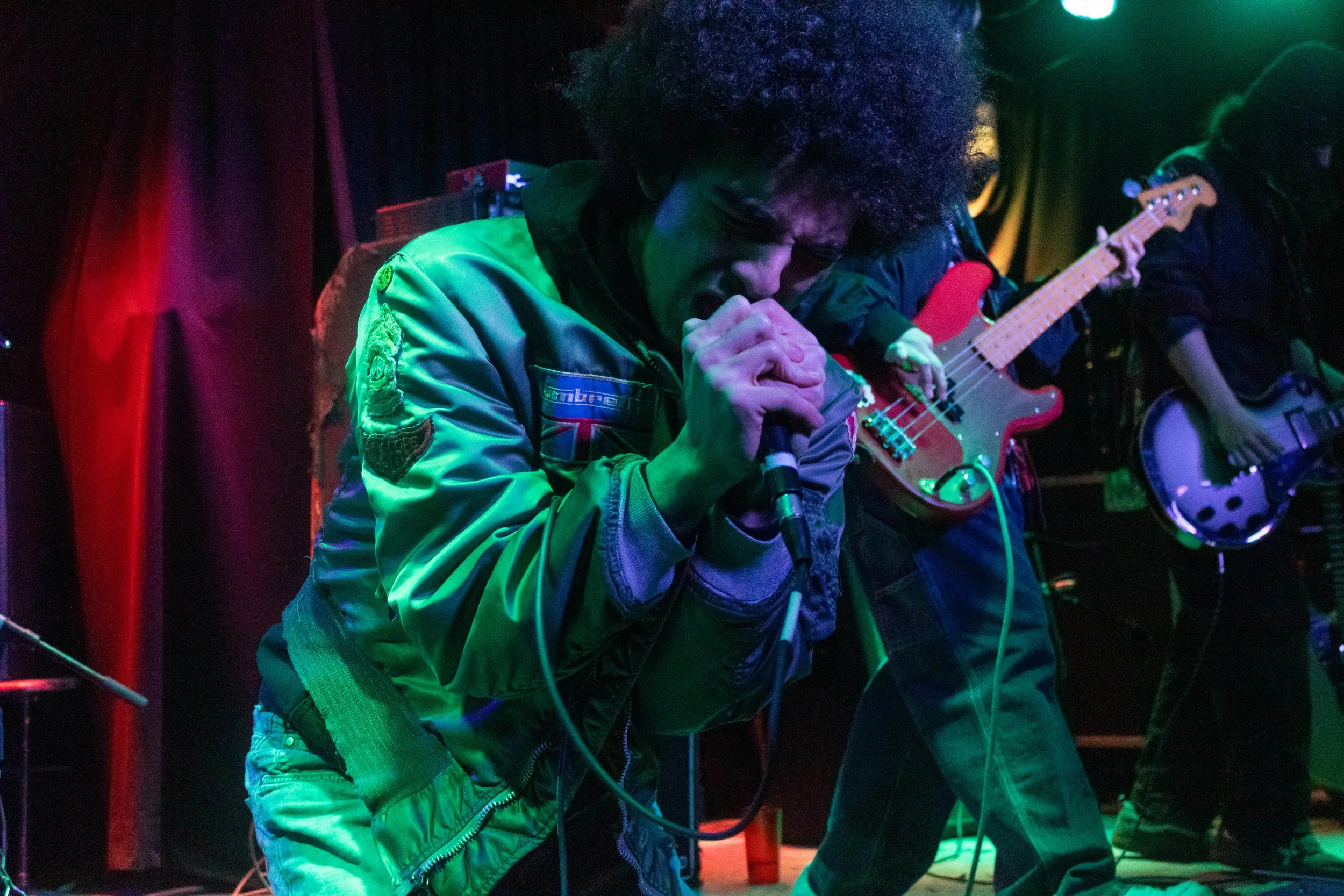 Vocalist Gabe Houston belts their song "sonic" into the mic.