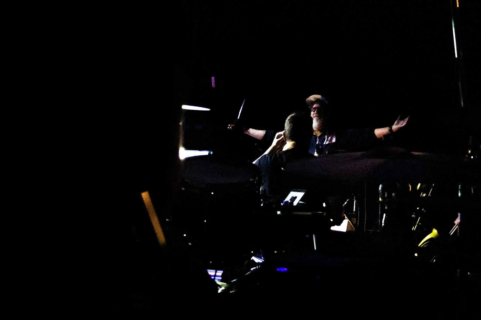 In the pitch black of the tent during the Act 2 transition, Pierce raises both arms to conduct the orchestra into a crescendo.