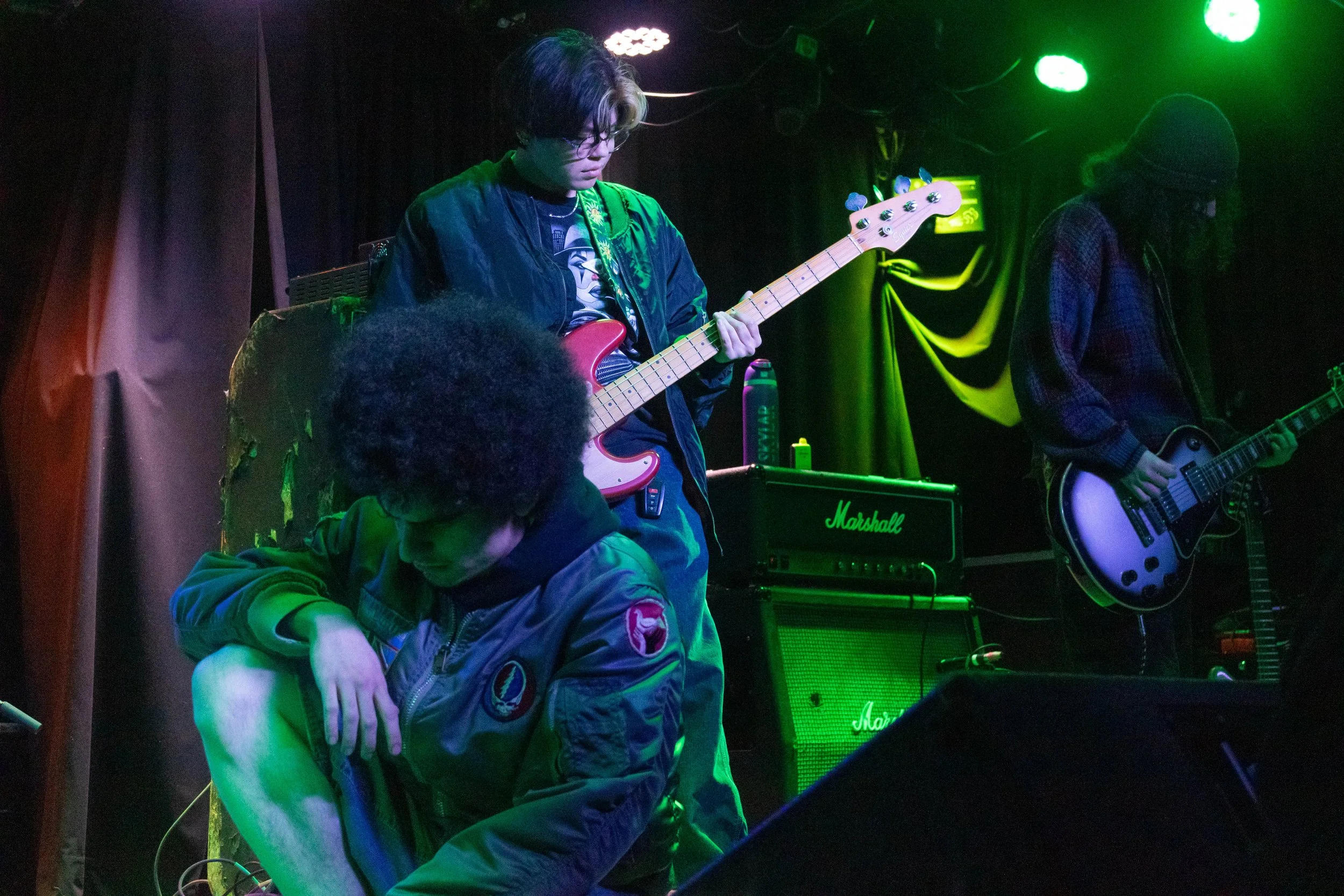 Vocalist Gabe Houston, bassist Angel Demello and guitarist Ian Coxon get into position before their set at Rubber Gloves Rehearsal Studios on Jan. 20, 2025.