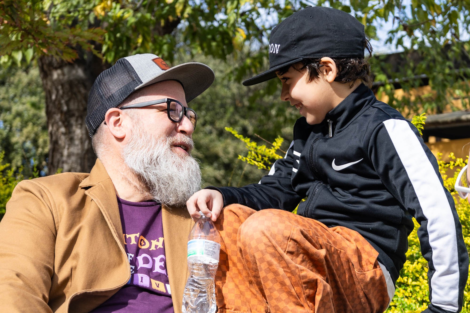 Pierce sits on a bench in Wolff's Park with his son Jonah as they laugh about an assignment Jonah worked on in his class.