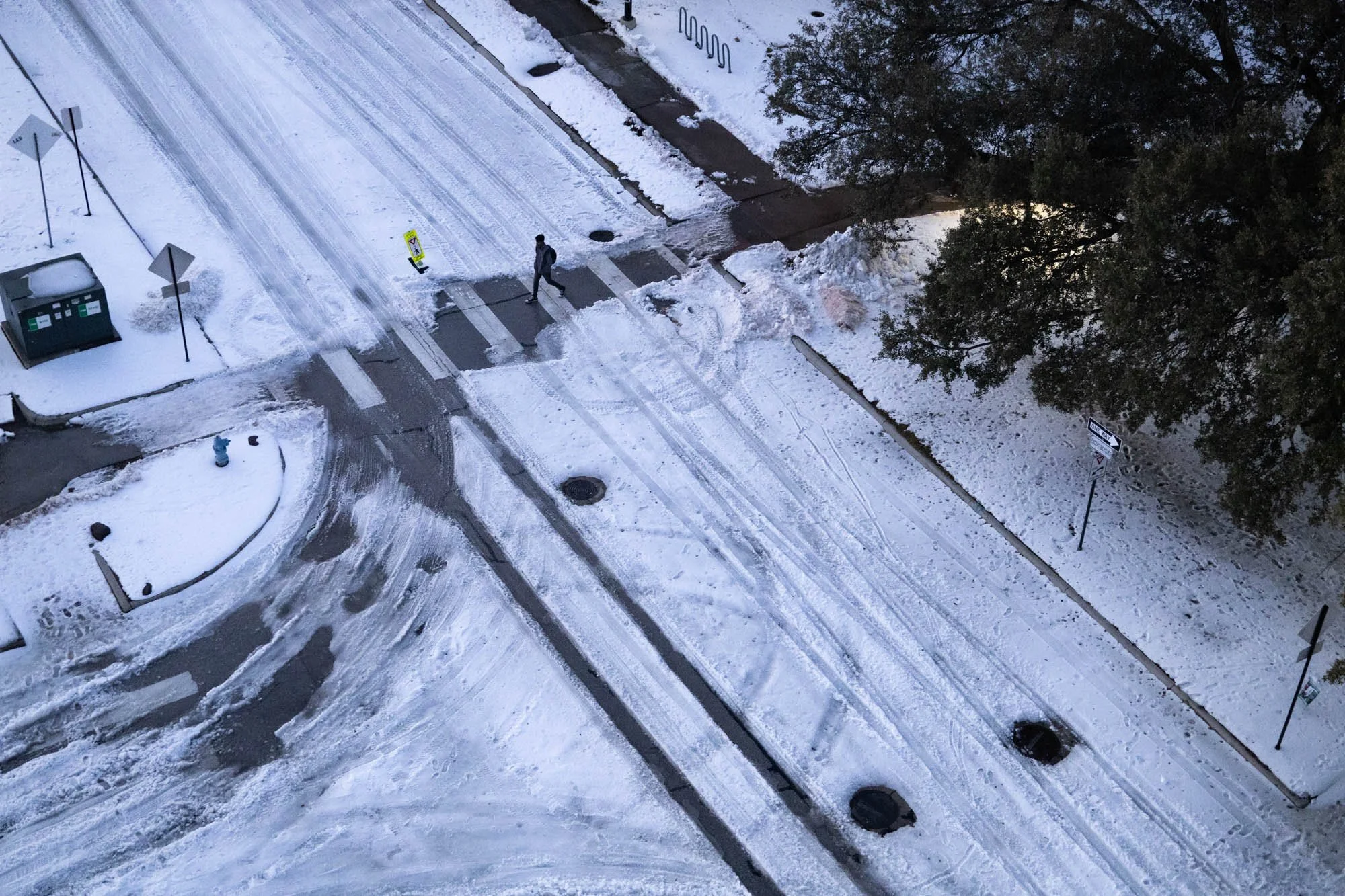 Campus Frozen Over - A University of North Texas student walks through the recently shoveled crosswalk at Highland Street on January 28, 2026. Denton received roughly 1.5 inches of snow, which remained frozen to the ground throughout the week. 