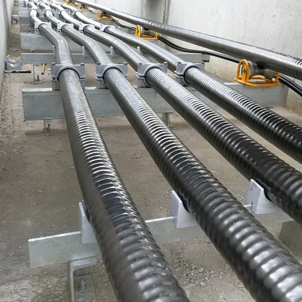 Multiple large black insulated pipes installed on metal supports in a construction or industrial setting.