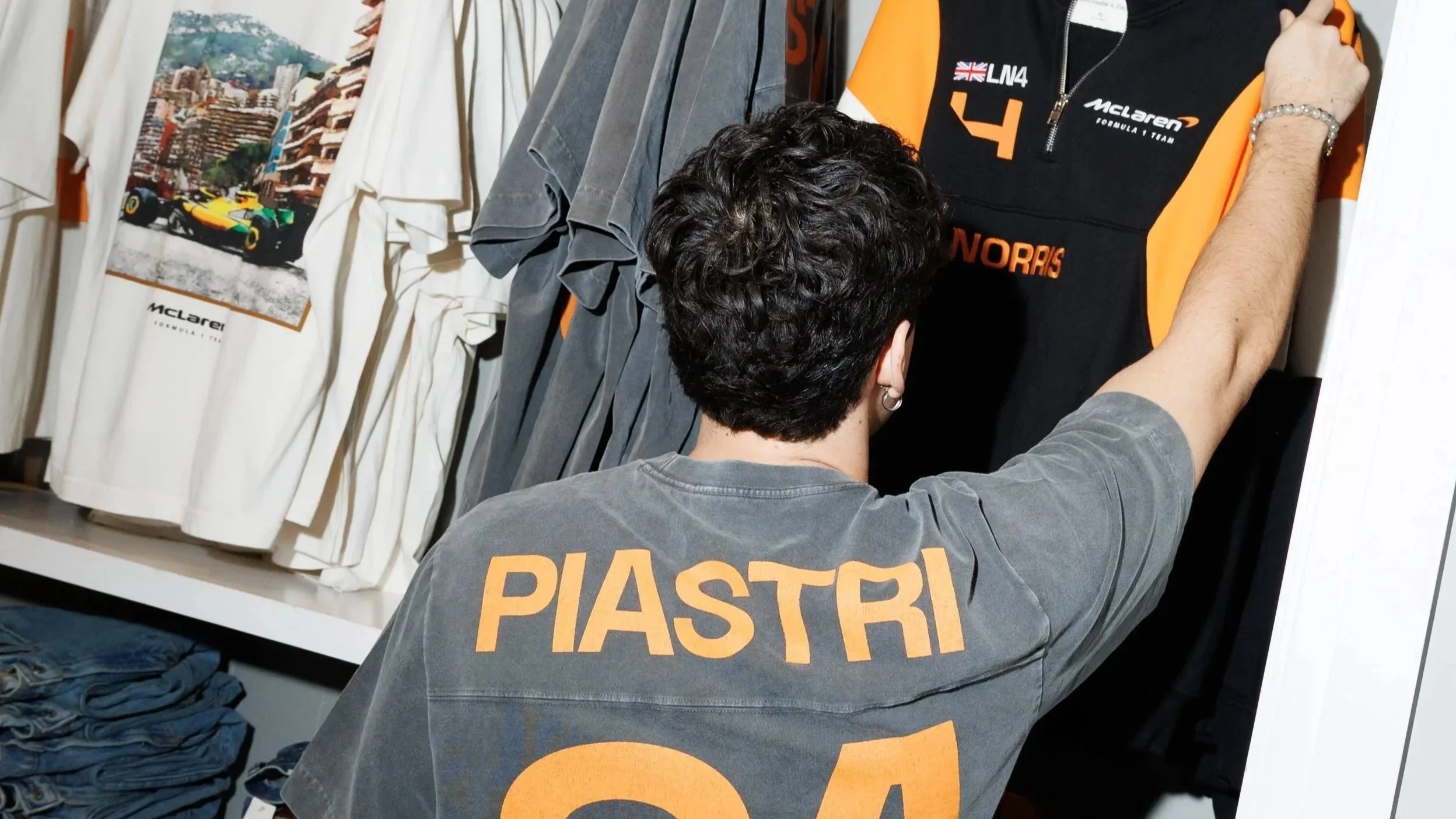 hombre joven de 18 a 21 años en una tienda abercrombie México viendo la nueva colección inspirada en el equipo de McLaren en la Formula 1