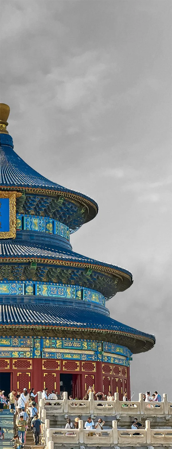 The Temple of Heaven in Beijing, China, with people walking around on a gray, cloudy day.