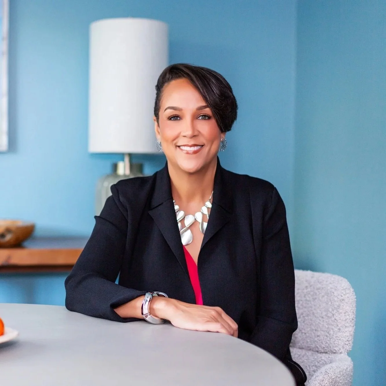 smiling black woman with short hair in a blue room