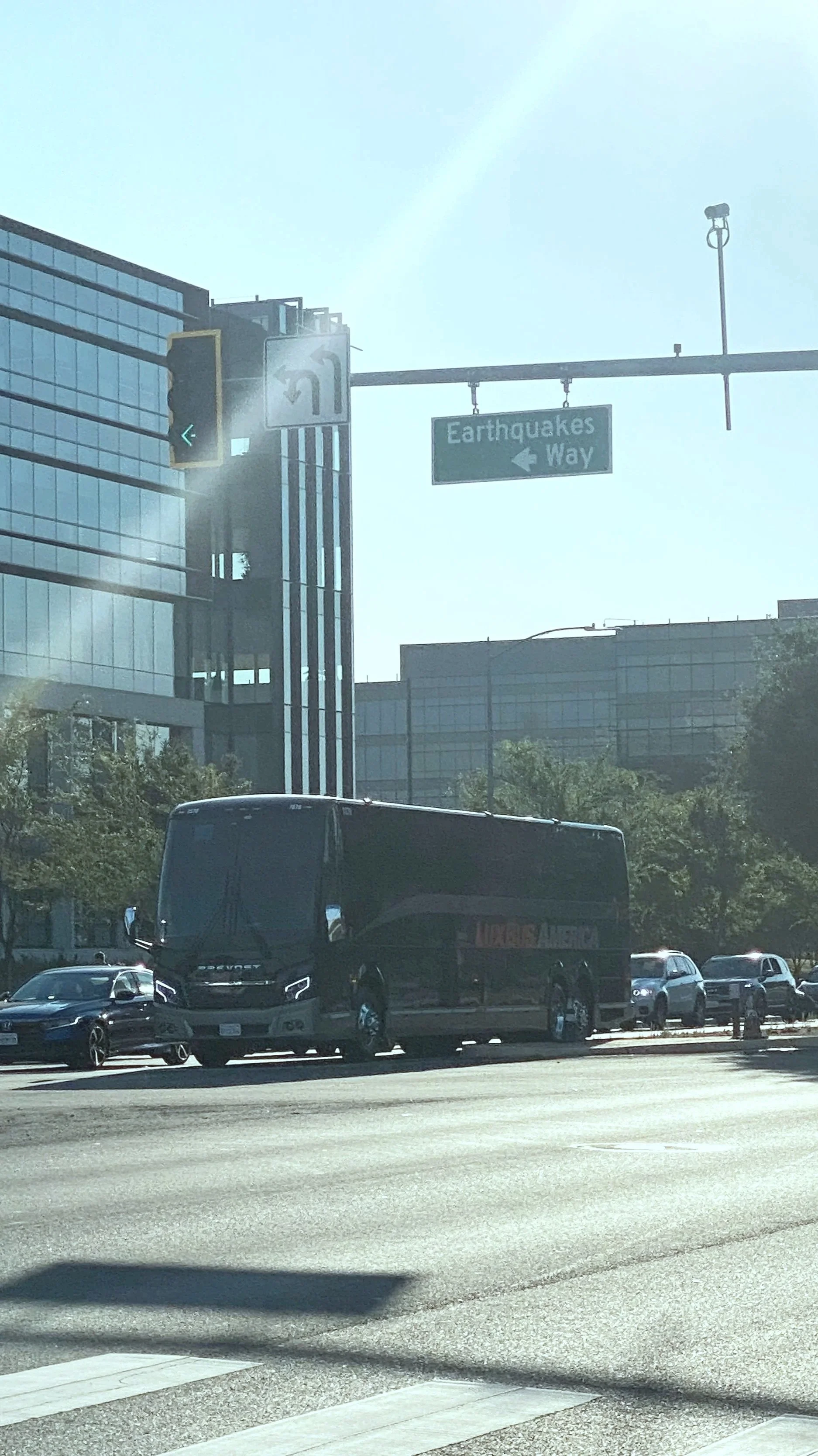 City street scene with office buildings, traffic, and a sign pointing to 'Earthquakes Way' indicating the direction for earthquakes. The San Jose Earthquakes are the local offical MLS team.