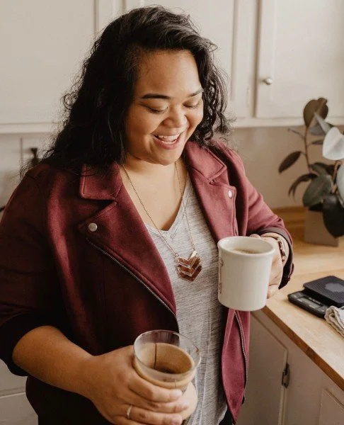 filipina woman smiling and holding a chemex and coffee mug