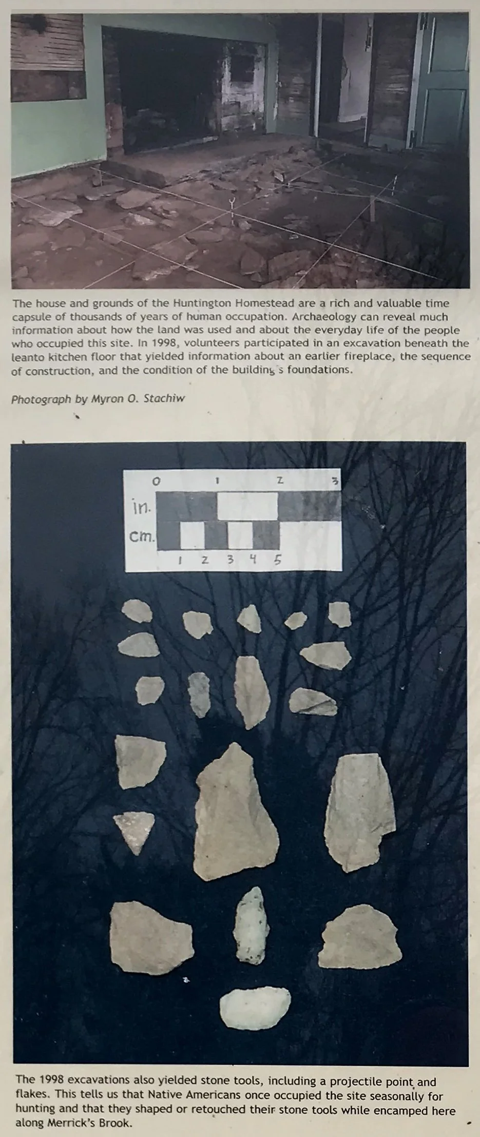 Photo of archaeological excavation site showing stone tools and flakes, with a diagram of measurements above. The scene features scattered stones and dirt, with leafless trees reflected in a background window.