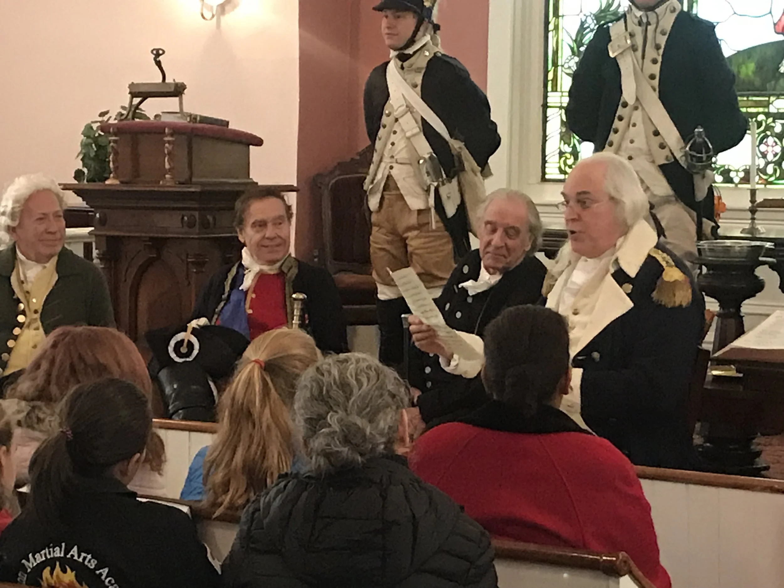 Historical reenactors dressed as soldiers from the American Revolutionary War speaking to an audience in our historic congregational Church.