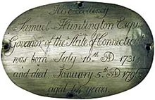Close-up of a carved stone with inscribed historical text about Samuel Huntington, mentioning his birth and death dates.