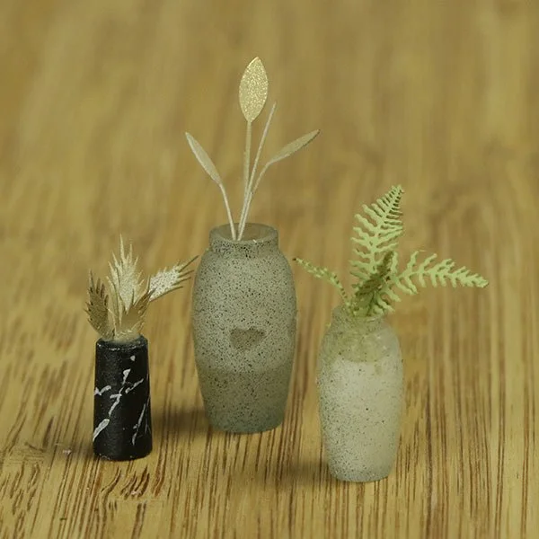 a scale model of a few vases of flowers