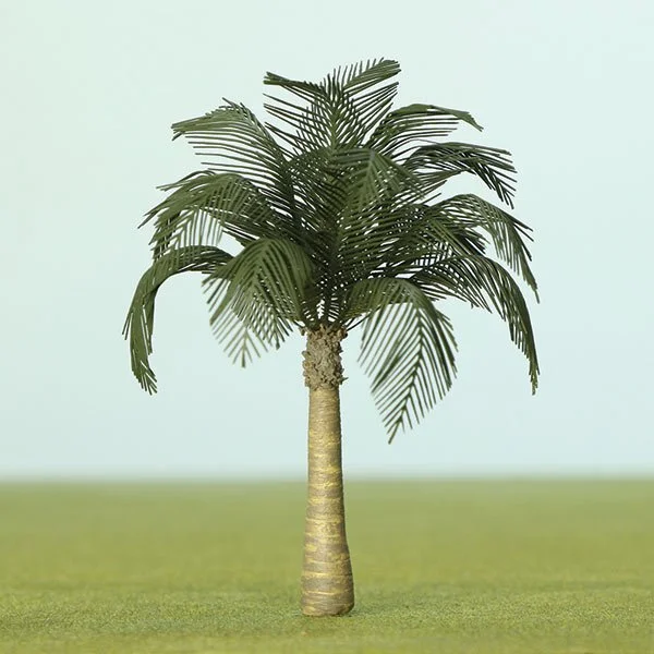 A single small model palm tree with a textured trunk and lush green fronds against a light background