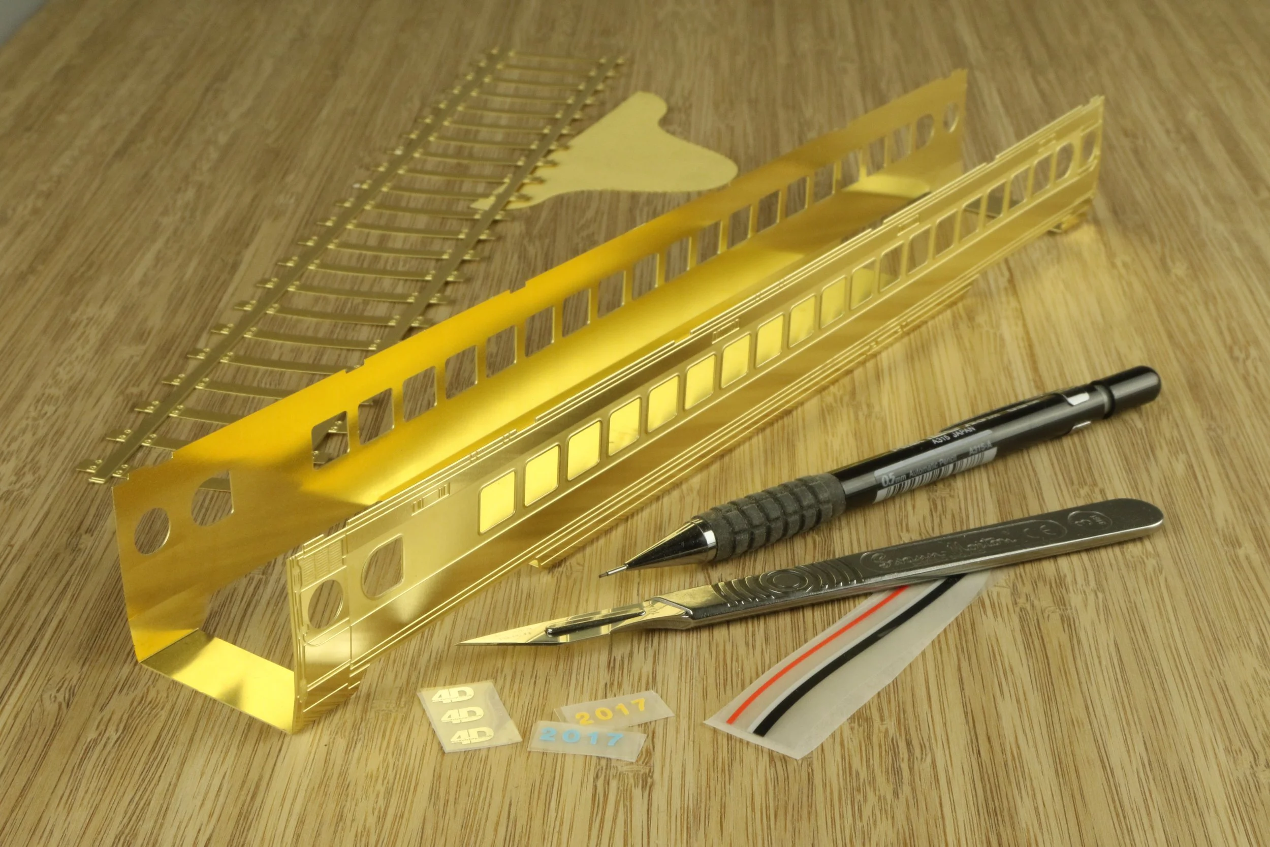 a train carriage assembly, half assembled. Constructed from etched brass parts.