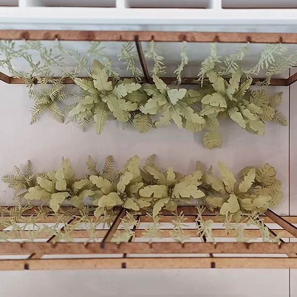 a model of a corridor covered in vines, banana plants and ferns