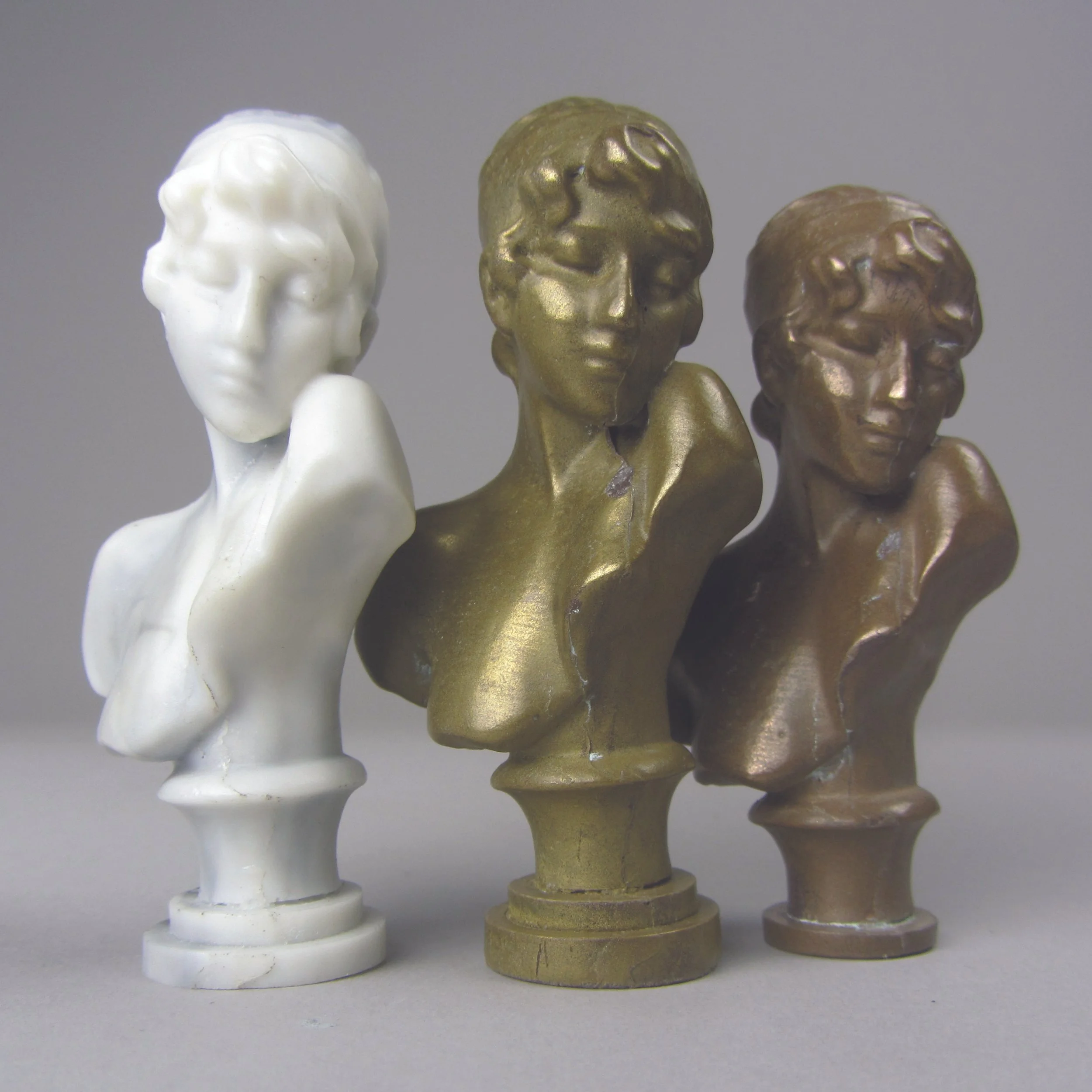 A marbled bust next to cold cast brass and bronze busts. Made in polyurethane