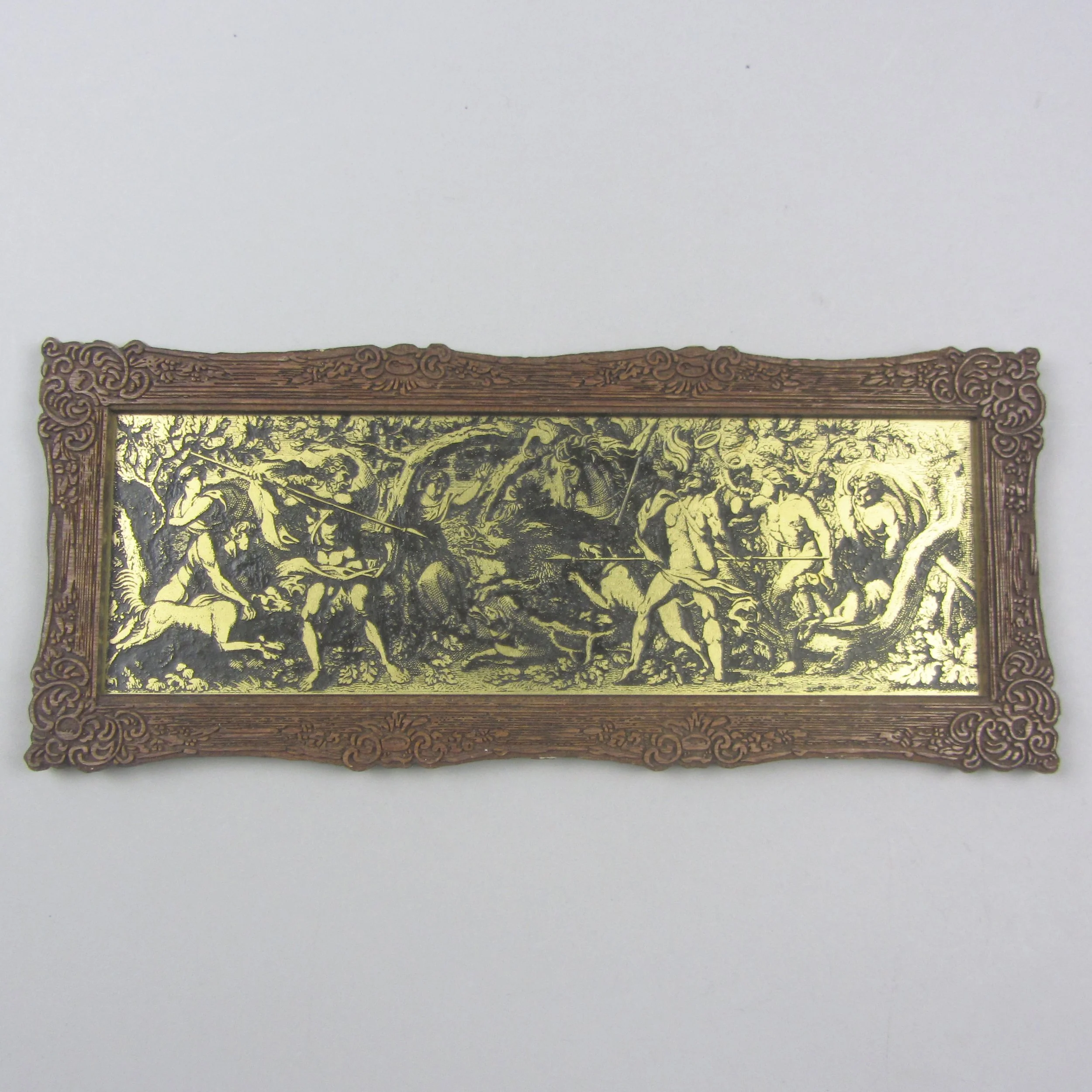 an artwork depicting cherubs, etched into brass with a black infill, within a lasercut plywood frame. 