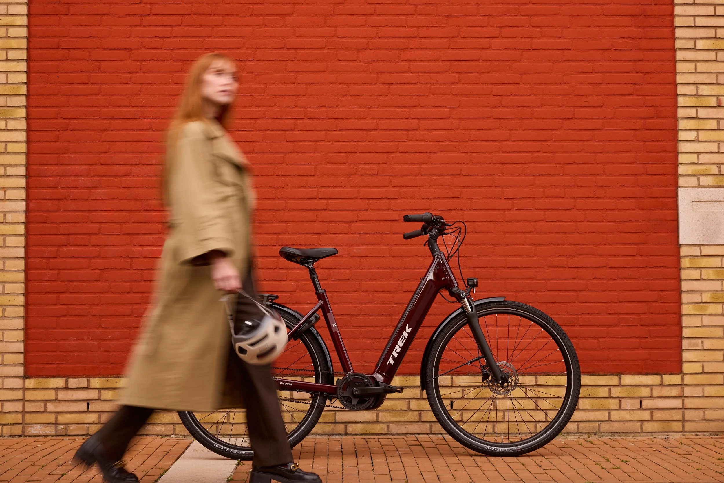 Une femme en manteau long passe devant le nouveau VAE de Trek, le District +