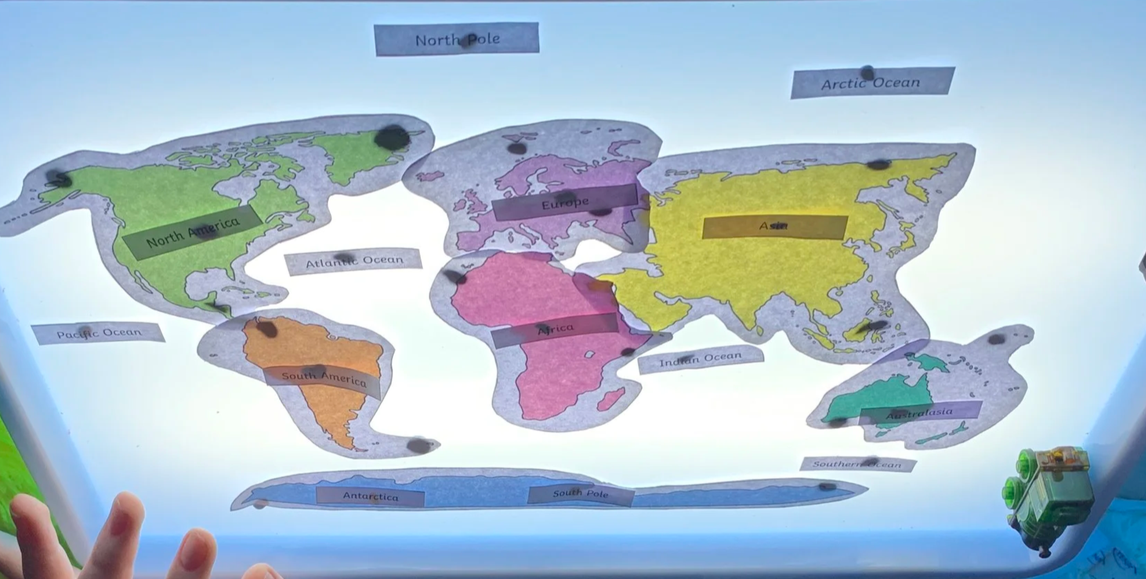Colorful illustrated world map with labels for continents and oceans, including North America, South America, Africa, Europe, Asia, Australia, Antarctica, Arctic Ocean, Atlantic Ocean, Pacific Ocean, Indian Ocean, and Southern Ocean.