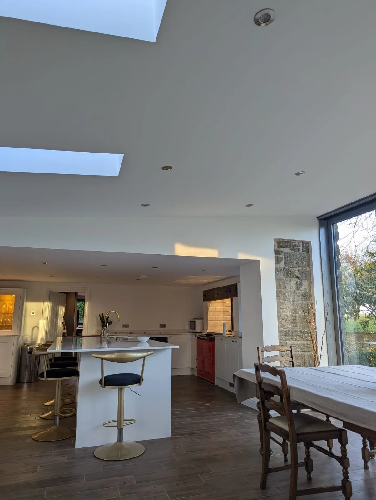 Open-plan kitchen and living room with breakfast bar and wood burner