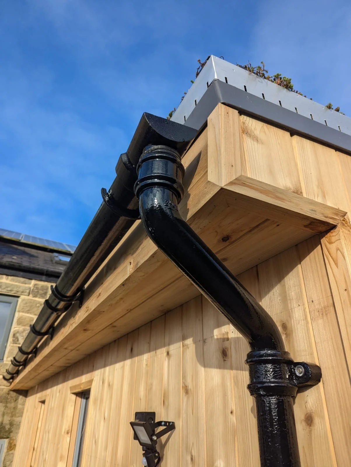 Outdoor living space with gently pitched roof and gutter