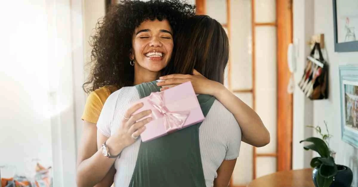 Two people hugging with a gift in hand