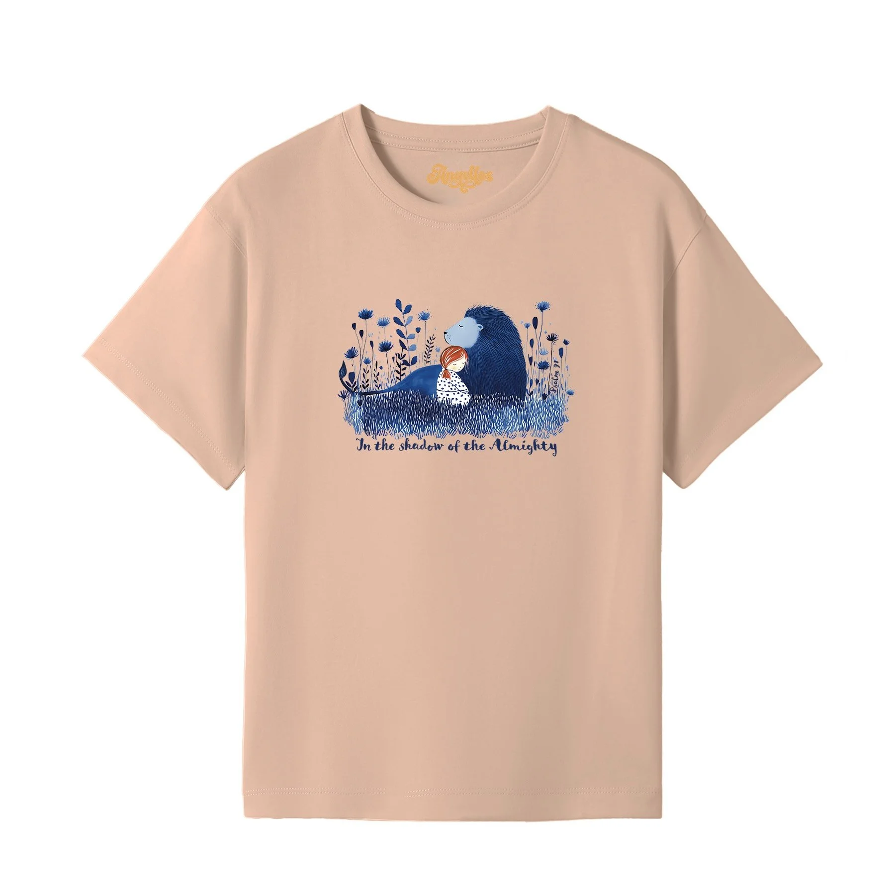 A blonde girl wearing a Christian t-shirt in peach color, with a picture of a blue lion and girl, with the words 'In the Shadow of the Almighty'