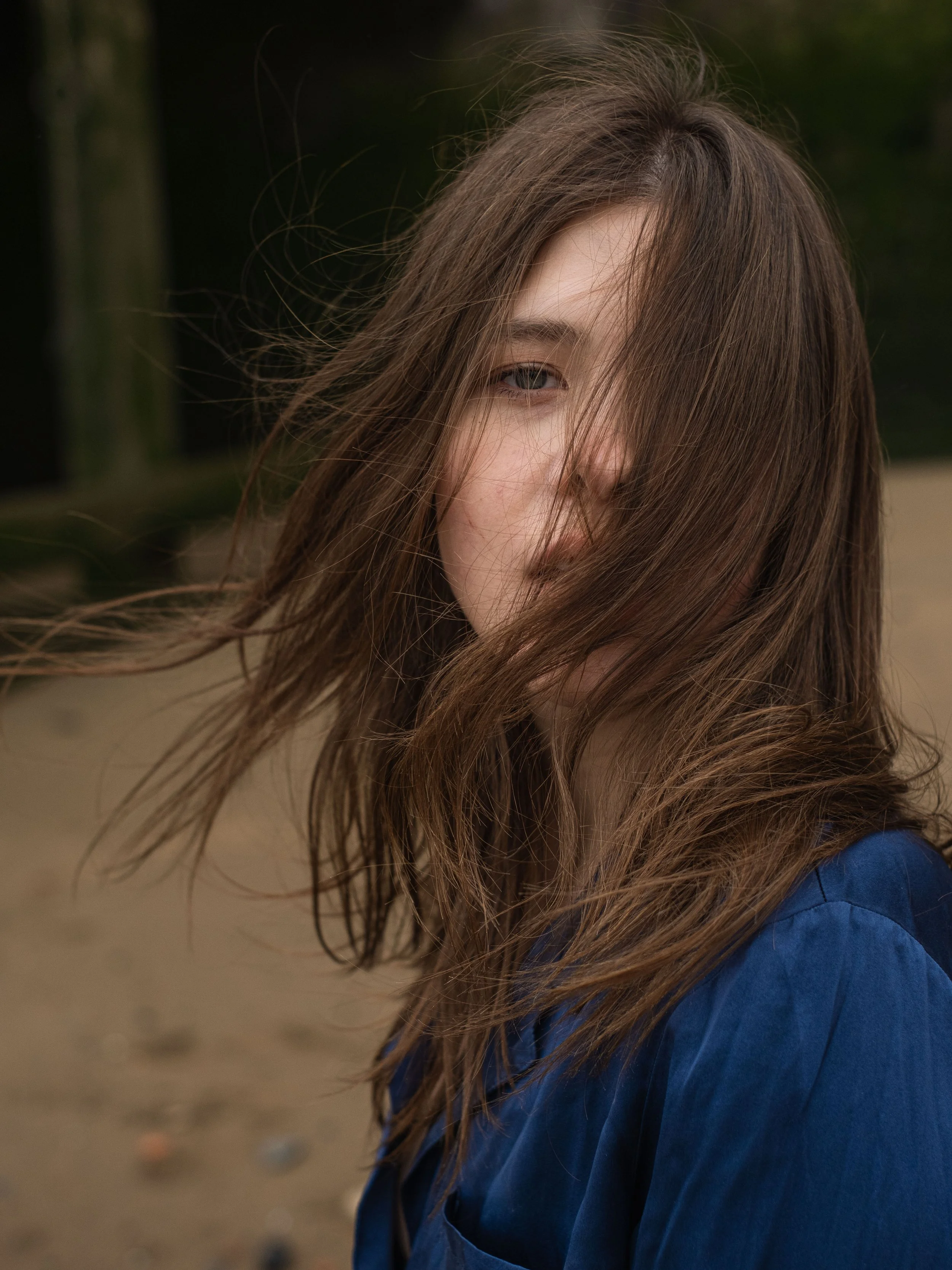 Portrait of a  woman with brown hair in  a blue shirt.