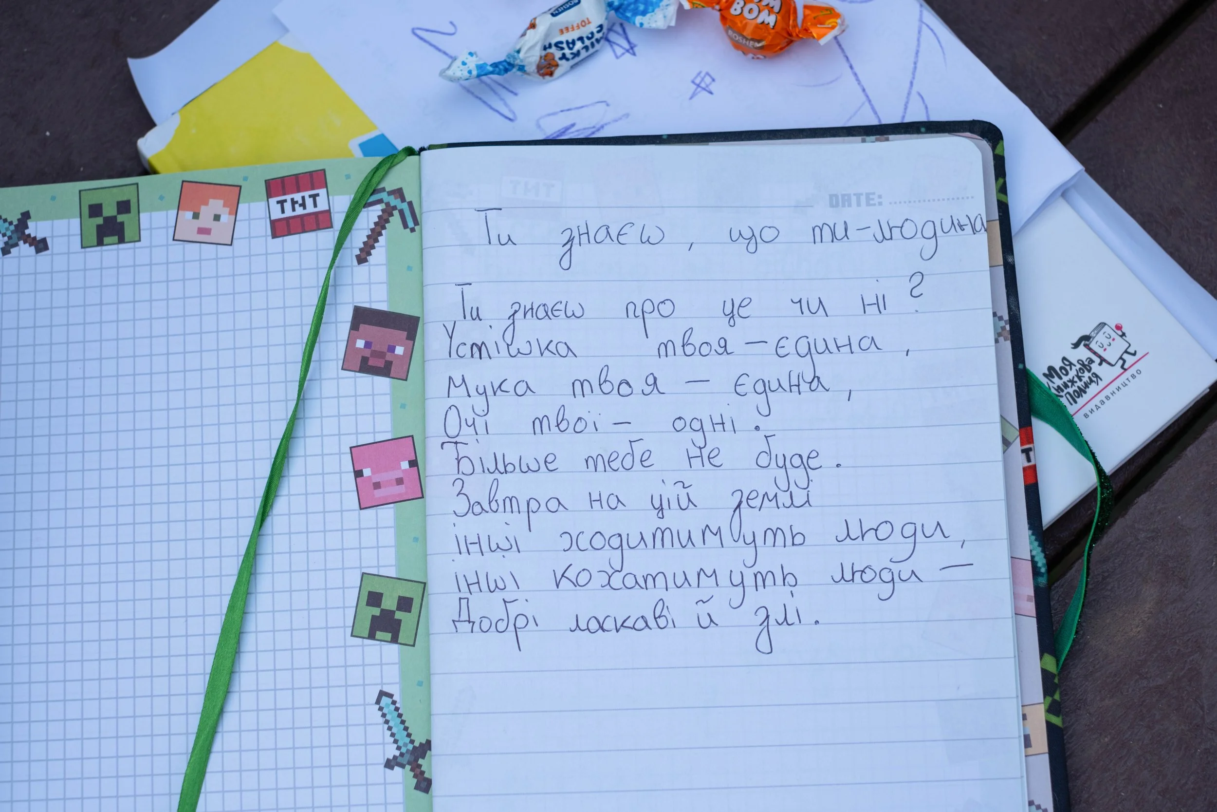 Open notebook with handwritten Ukrainian text.