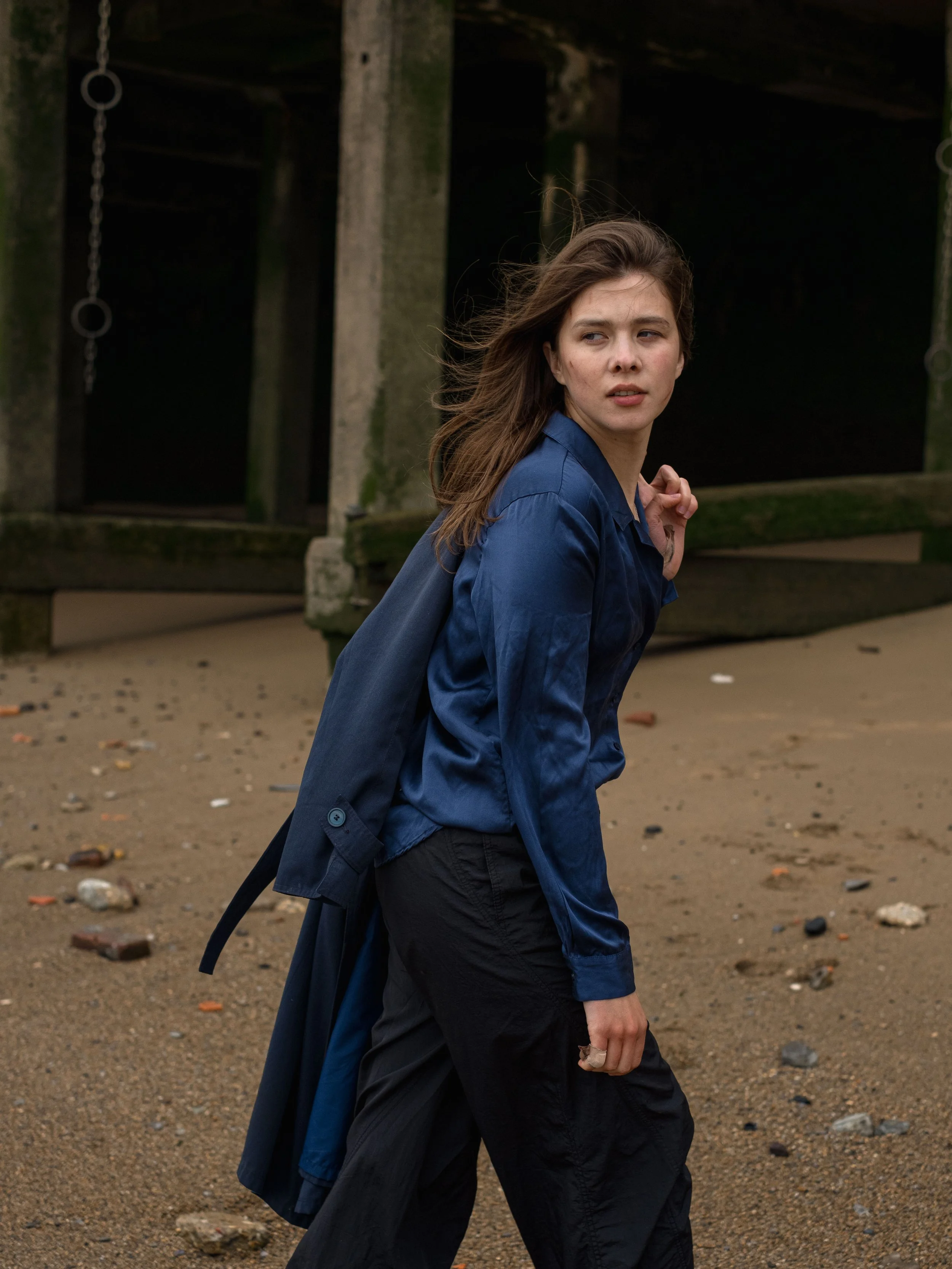 Portrait of a woman with brown hair wearing a blue satin shirt.