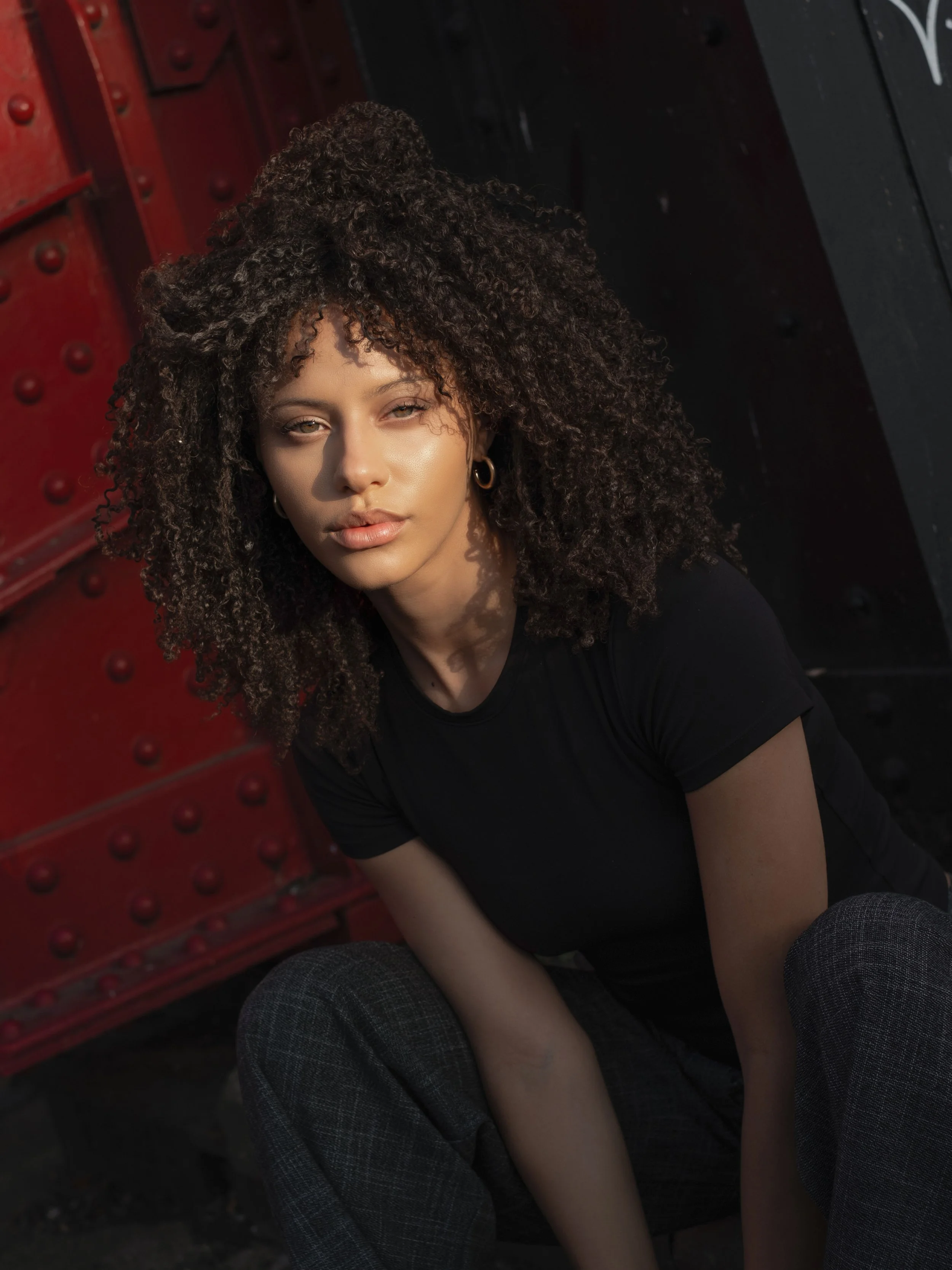 Portrait of a woman against a red and black background.