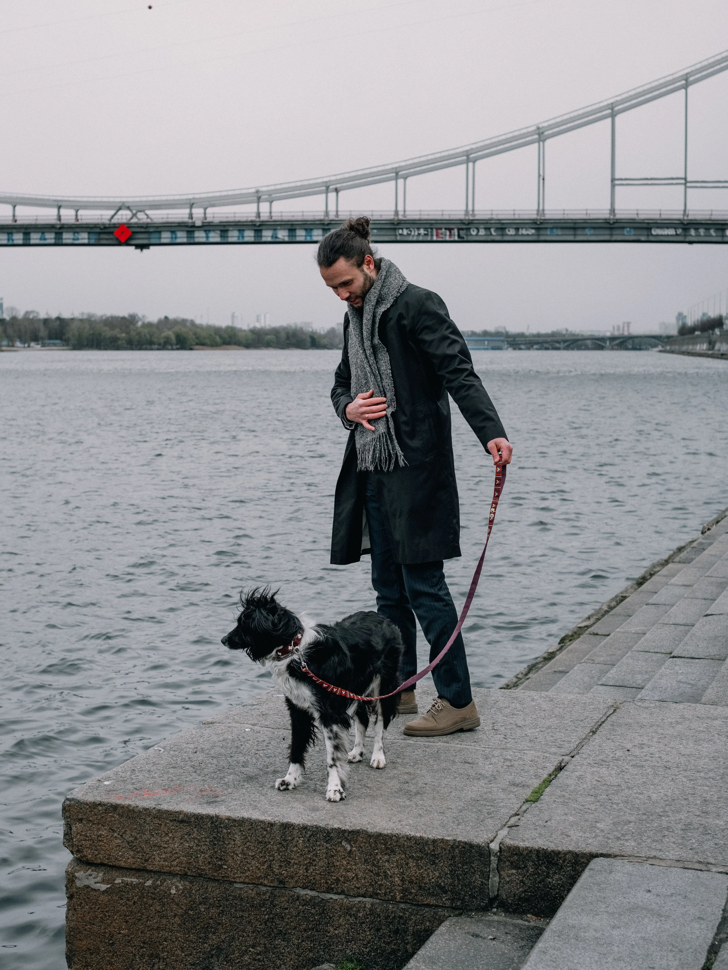 A man with a dog by the water.