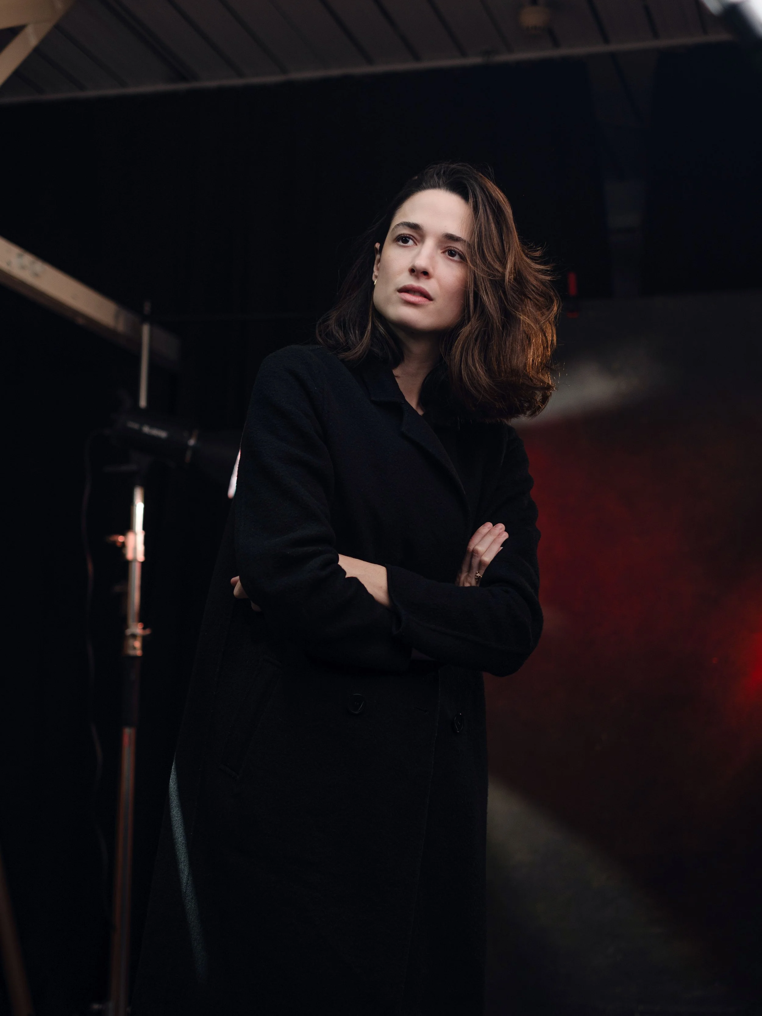Portrait of a woman standing in a dark room.