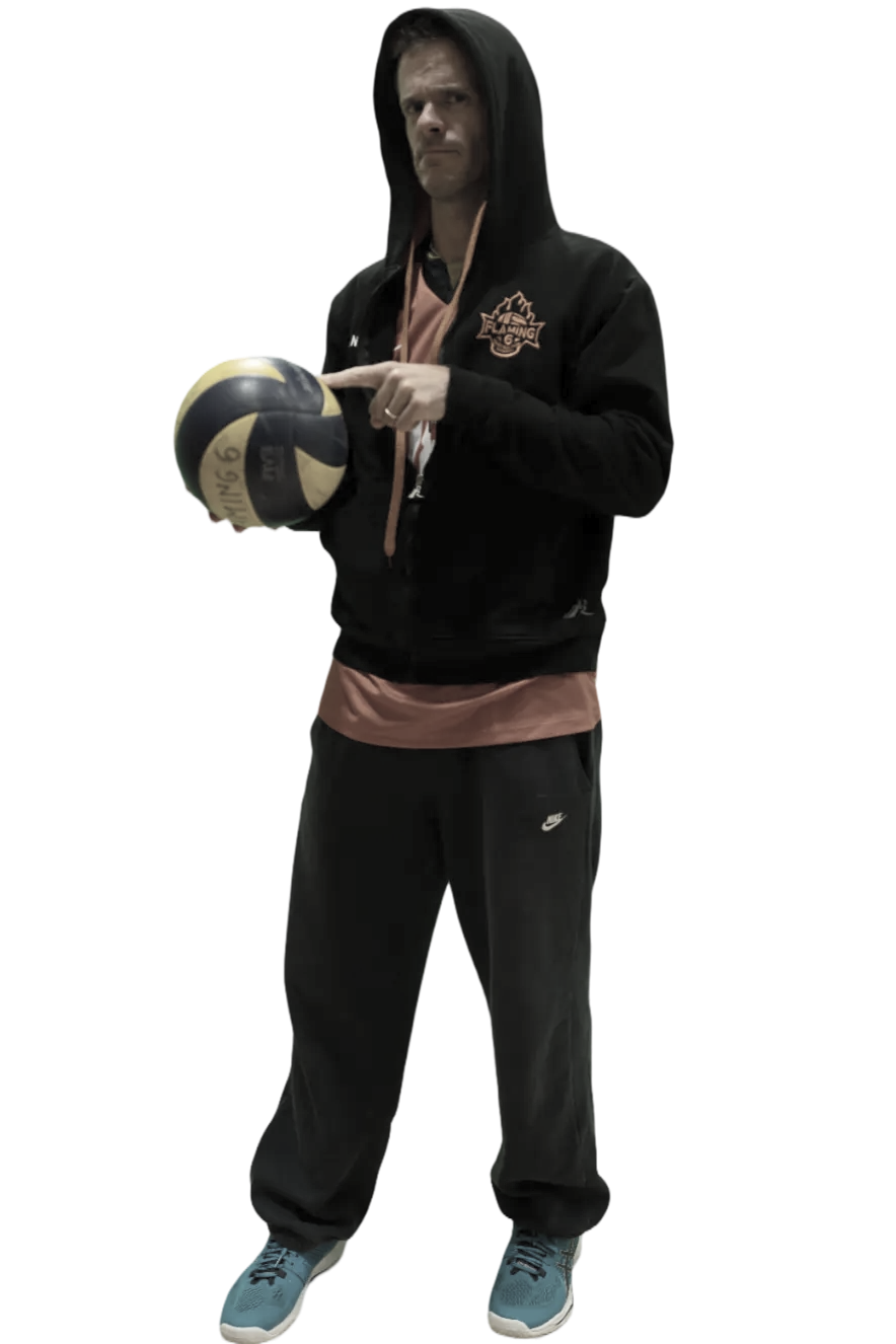 A man in a black hoodie holding a volleyball, standing on a solid black background.