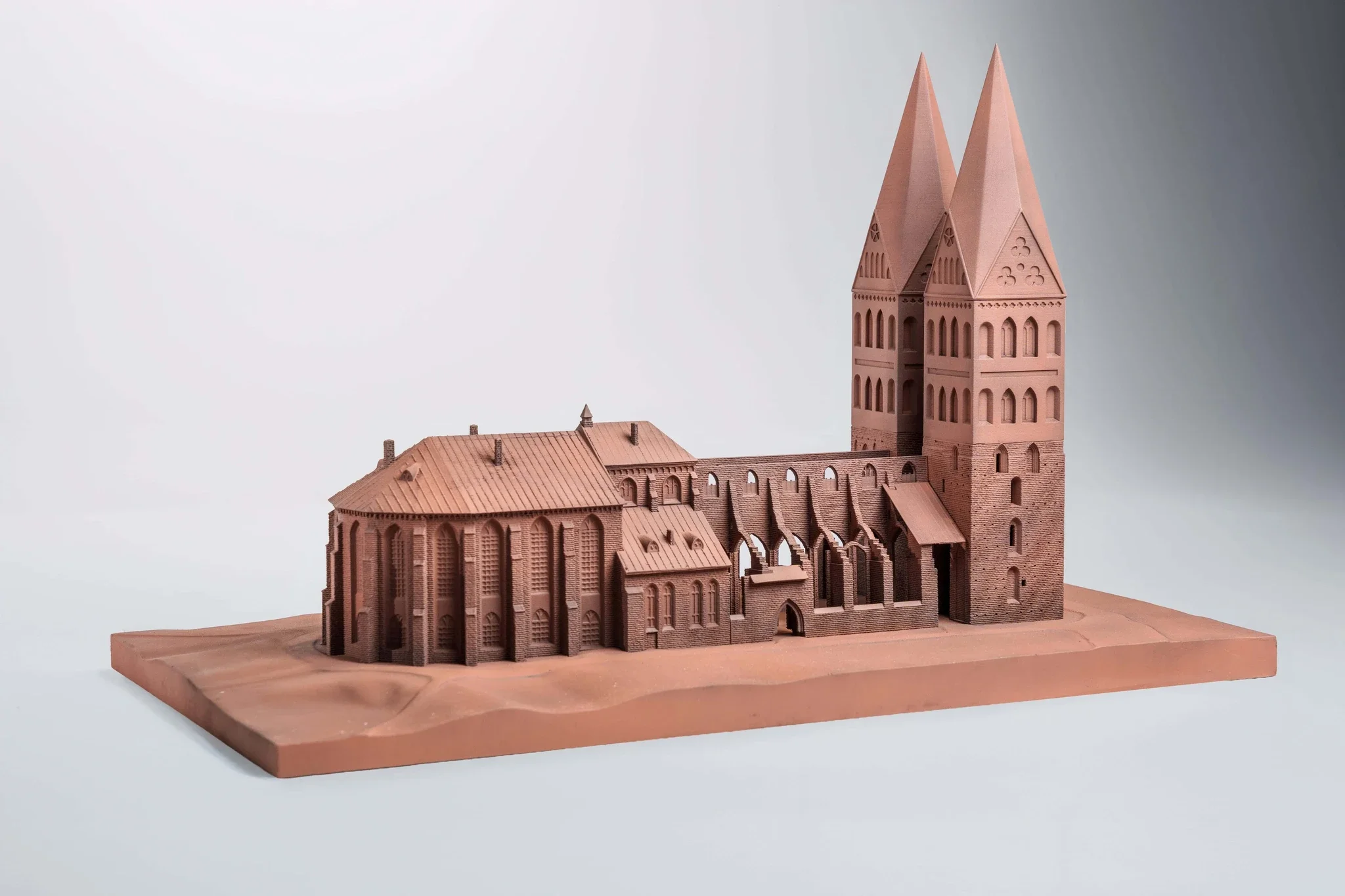 Detail of a limestone model of a Gothic-style cathedral with twin spires, arches, and stained glass windows.