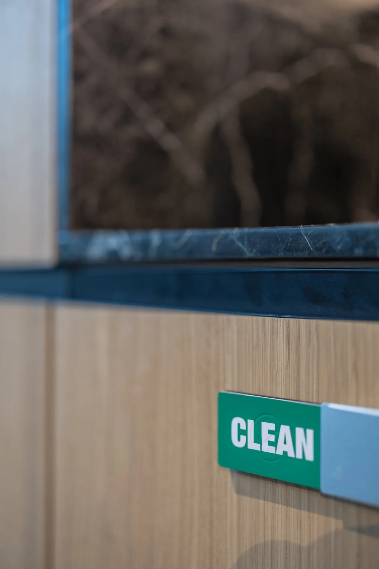 A close-up of a wooden cabinet with a sticker that says 'CLEAN' attached to it.