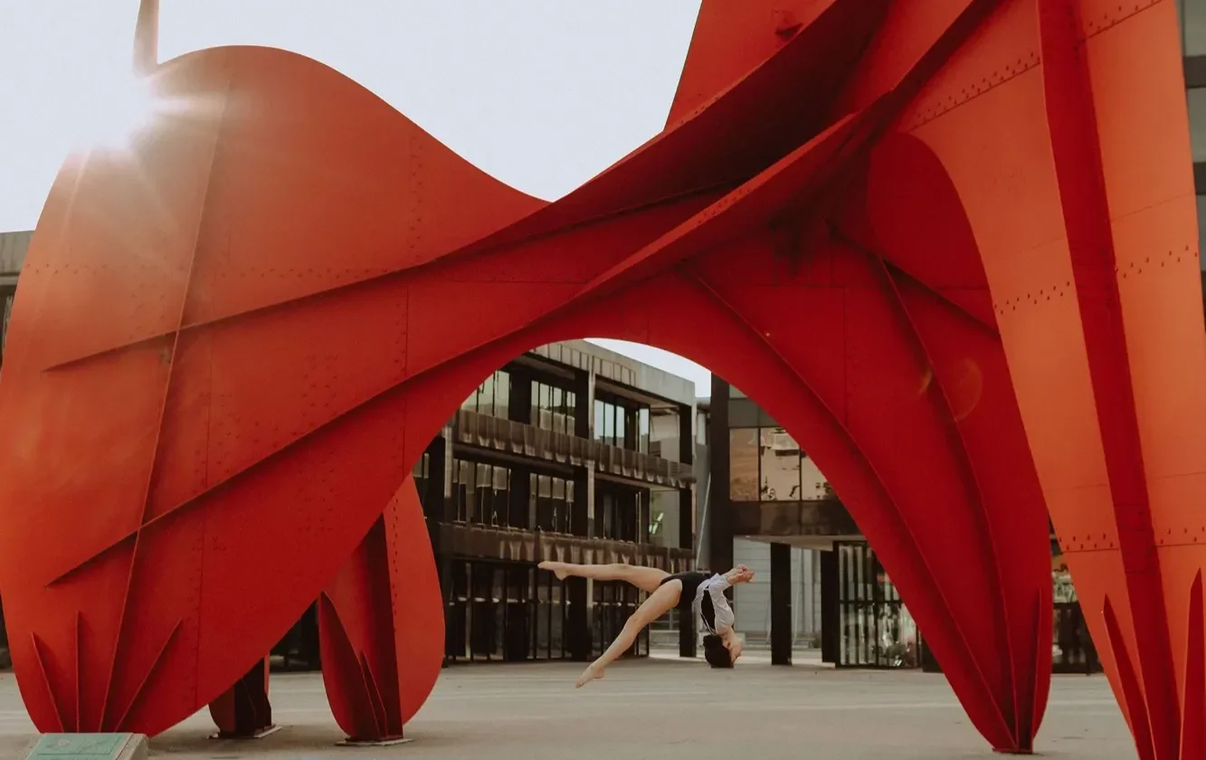youth GRTA athlete flipping in front of Calder sculpture